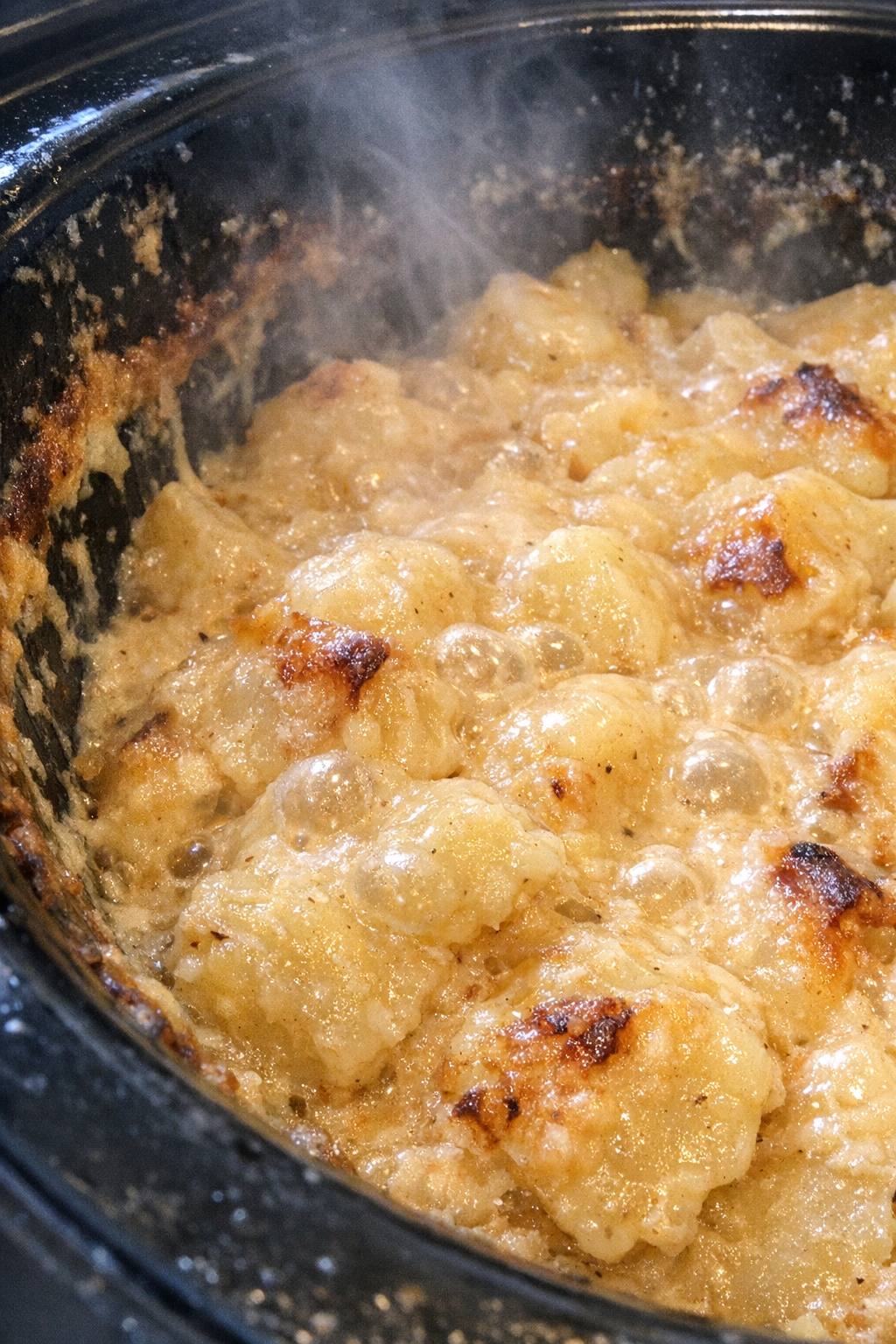 Slow cooker potluck potatoes bubbling in creamy golden sauce