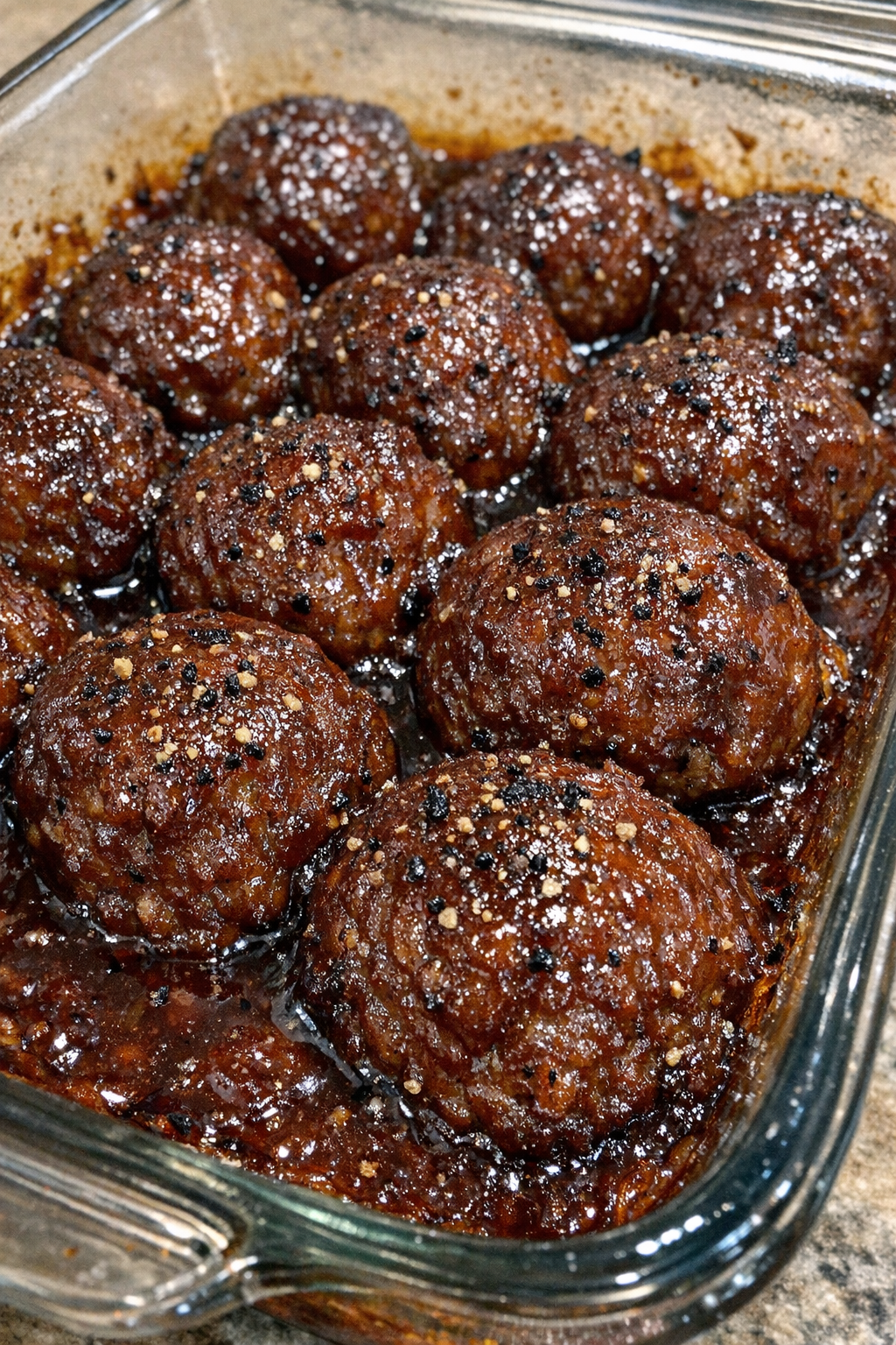 Finished beef BBQ meatballs baked in a glass casserole dish