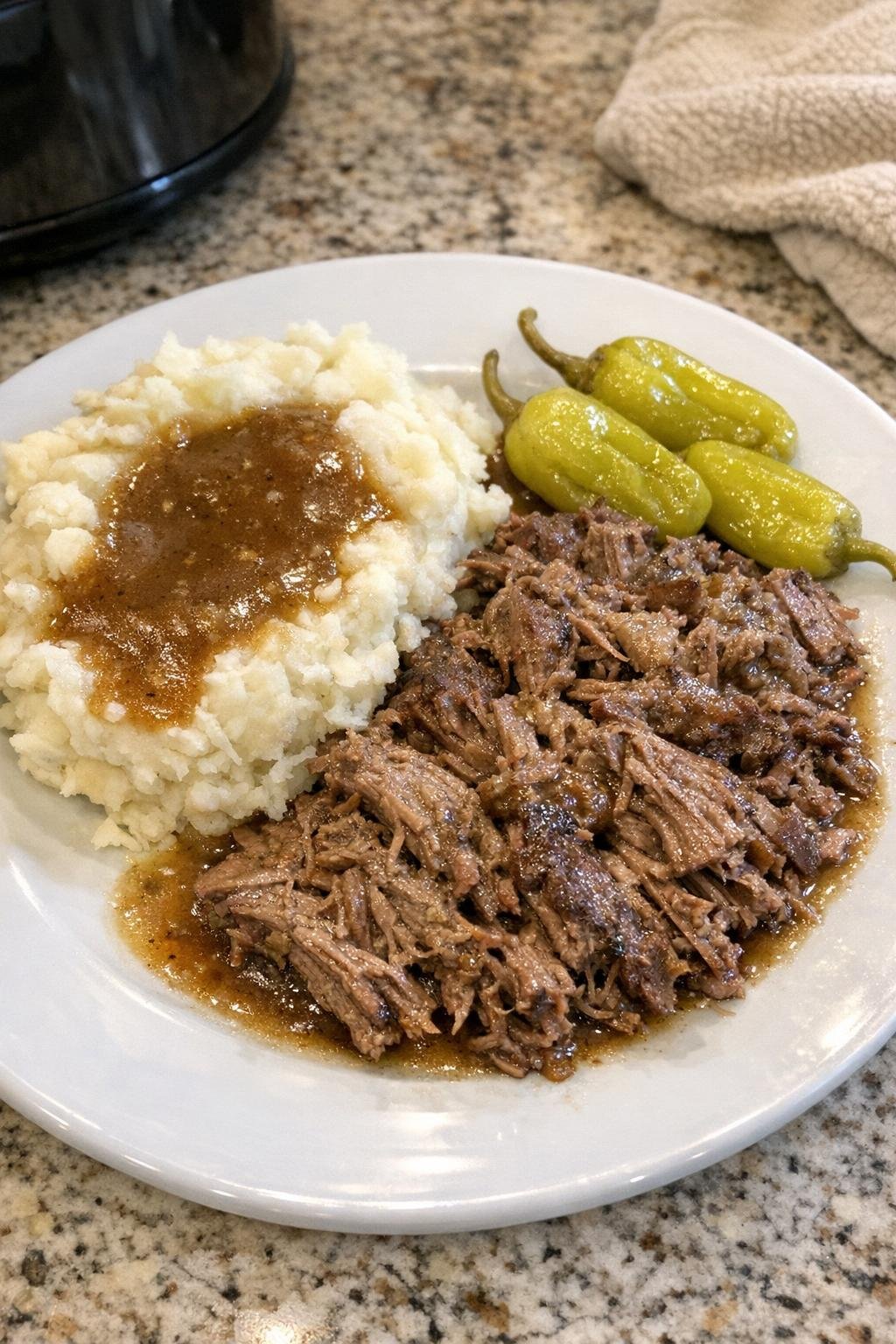 Tender shredded beef roast with gravy and pepperoncini