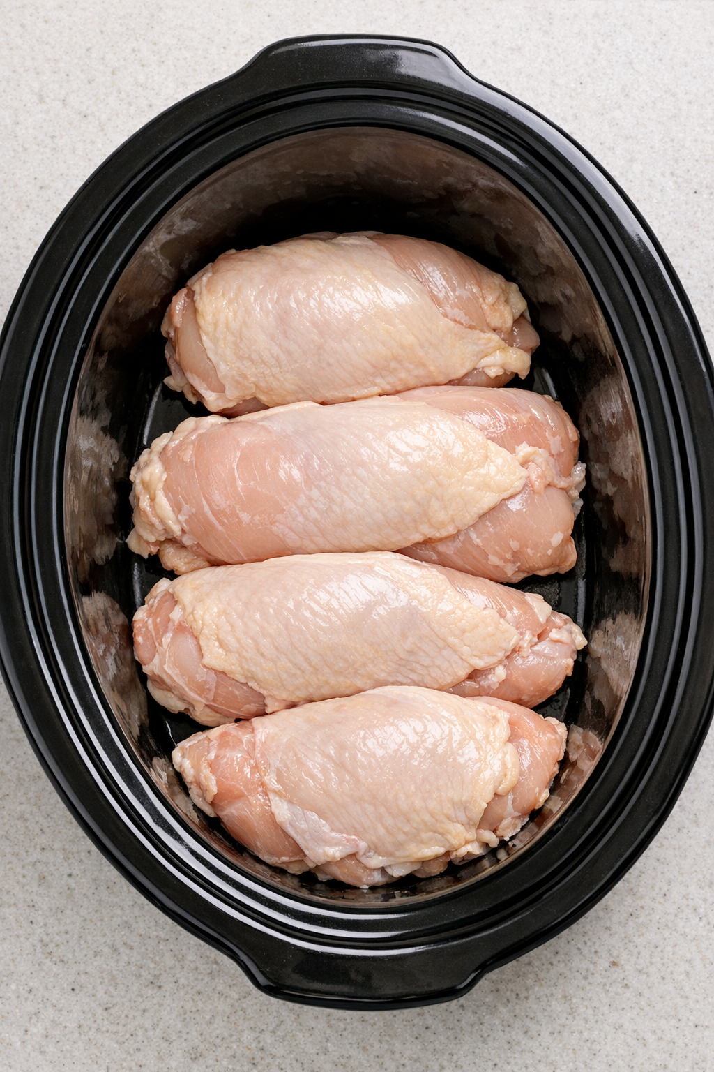 Chicken breasts arranged in the slow cooker