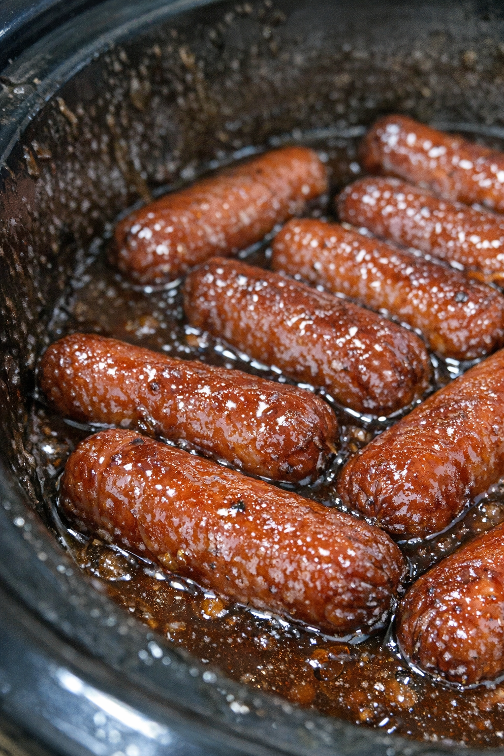 Slow cooker hot dogs in dark amber sauce