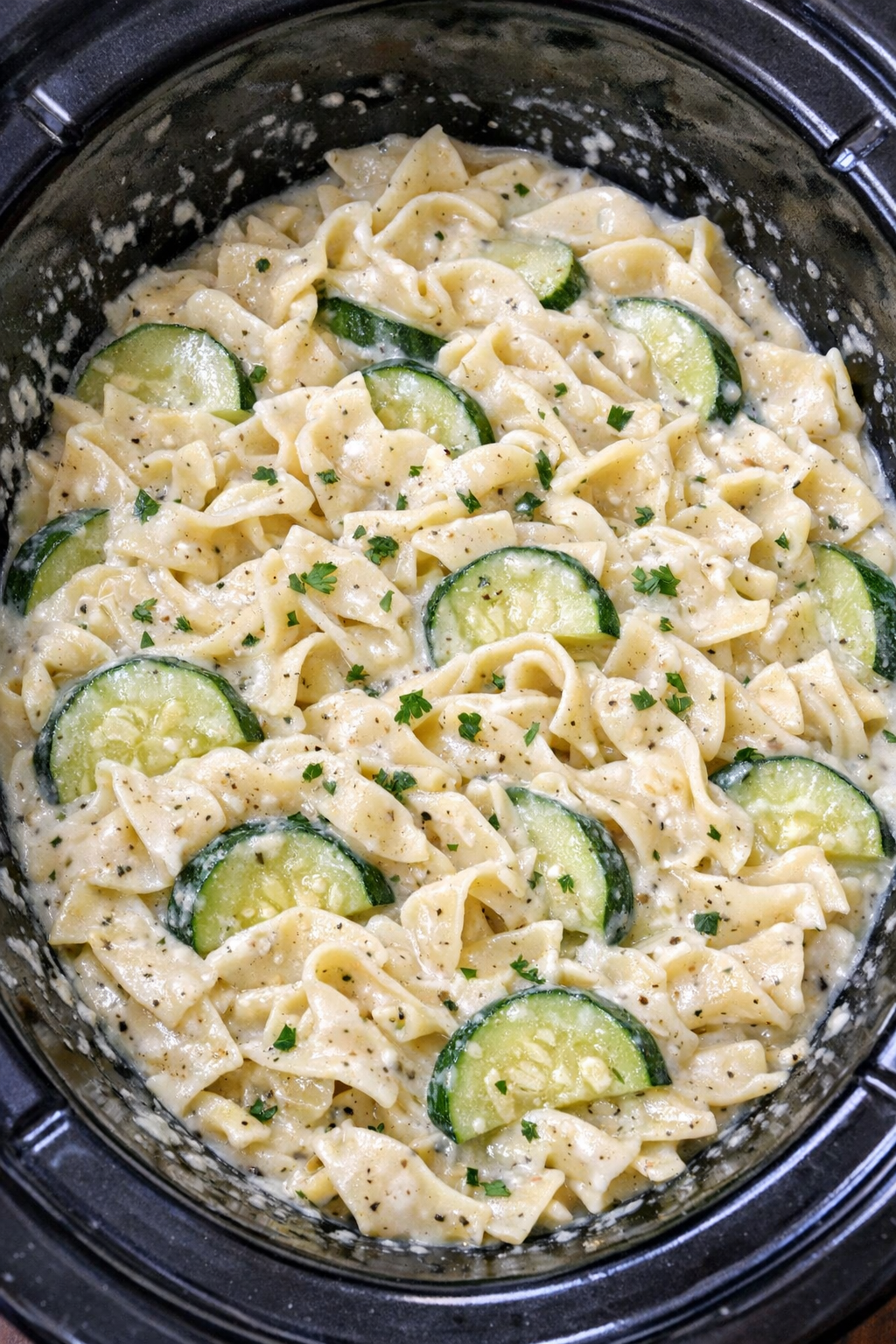 Slow cooker Amish zucchini cream noodles in a black slow cooker