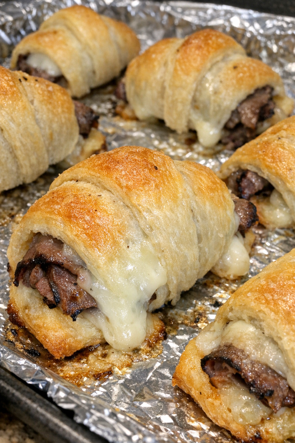 Oven baked beef french dip bites on a foil-lined baking sheet