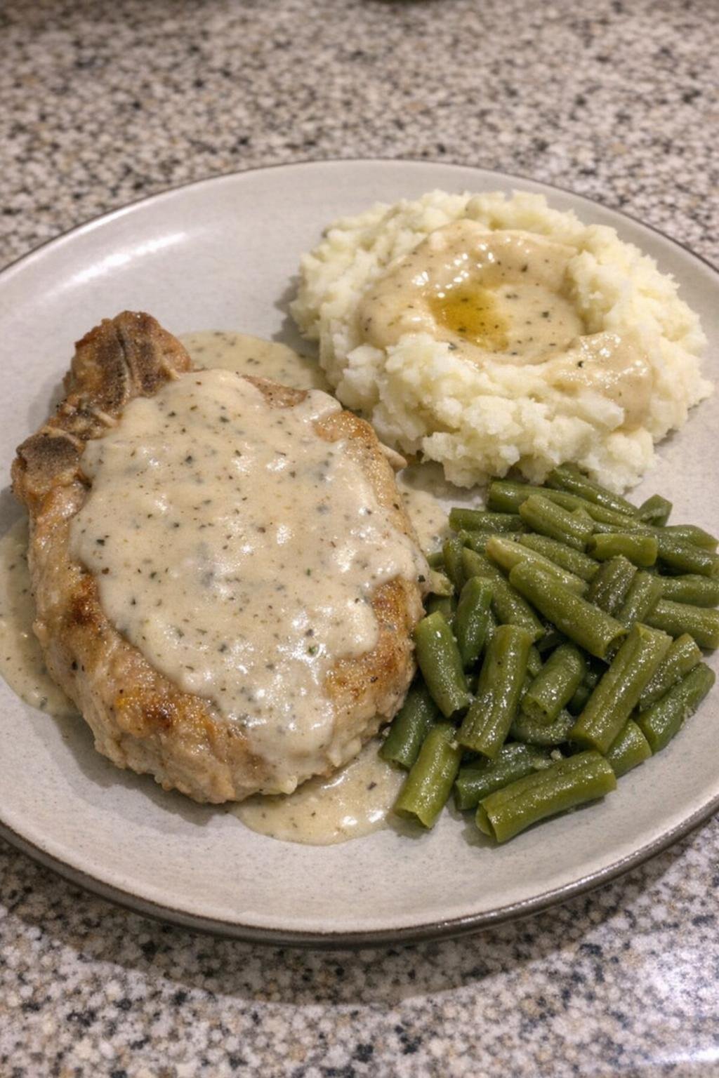 Plated pork chop with mashed potatoes and green beans