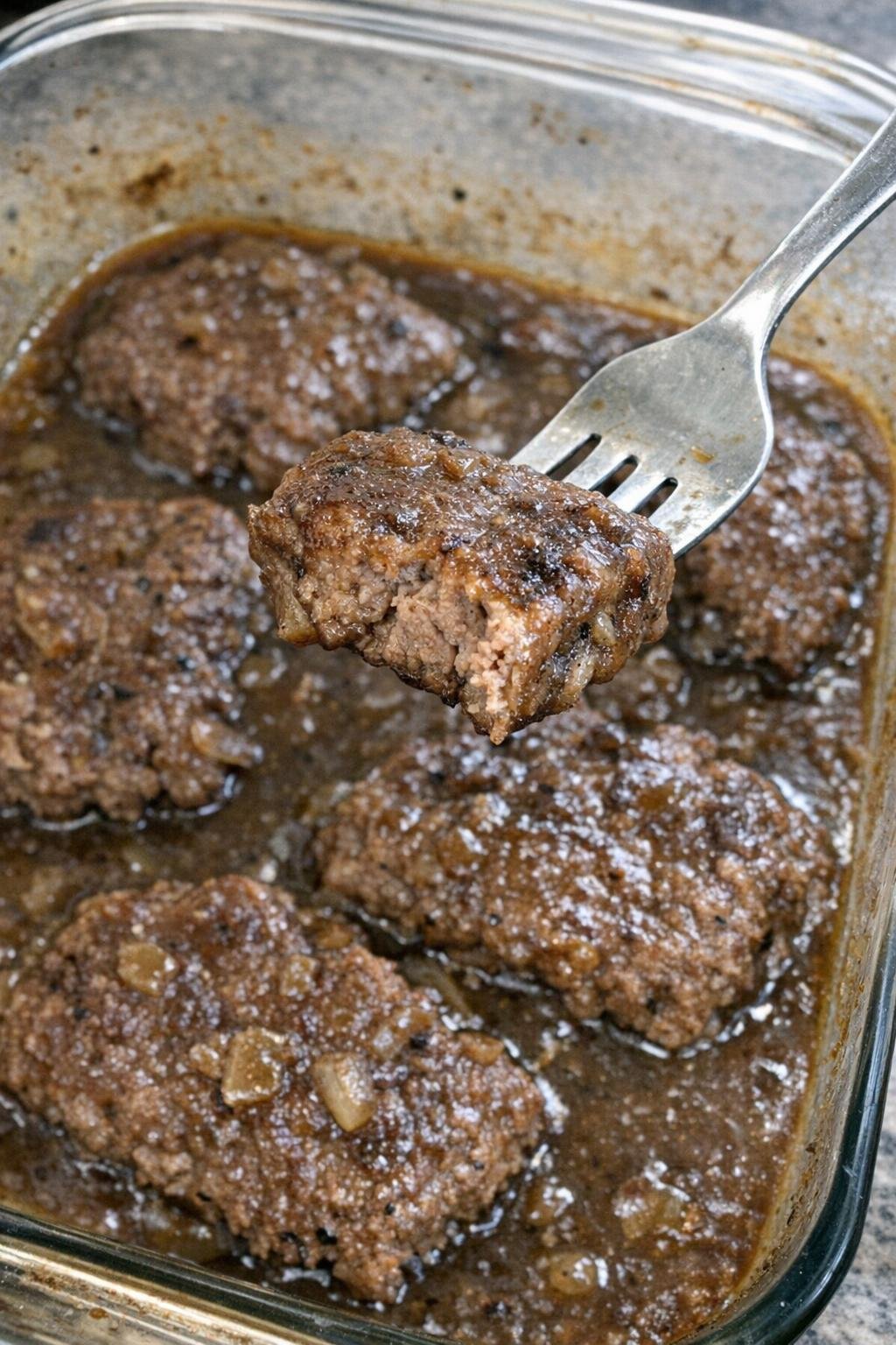 Cube steak in gravy in a glass baking dish