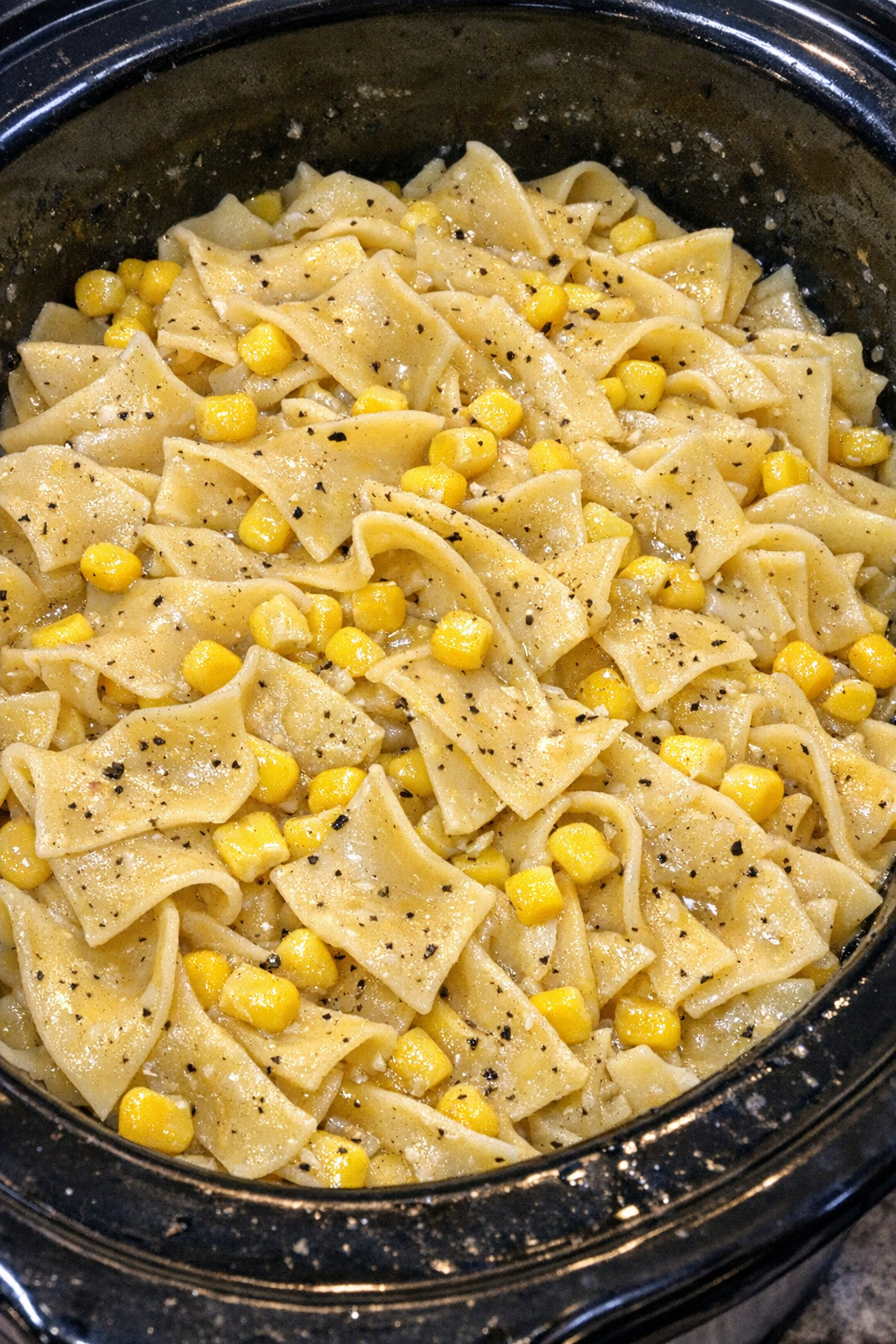 Slow cooker Amish sweet corn noodles in a black slow cooker