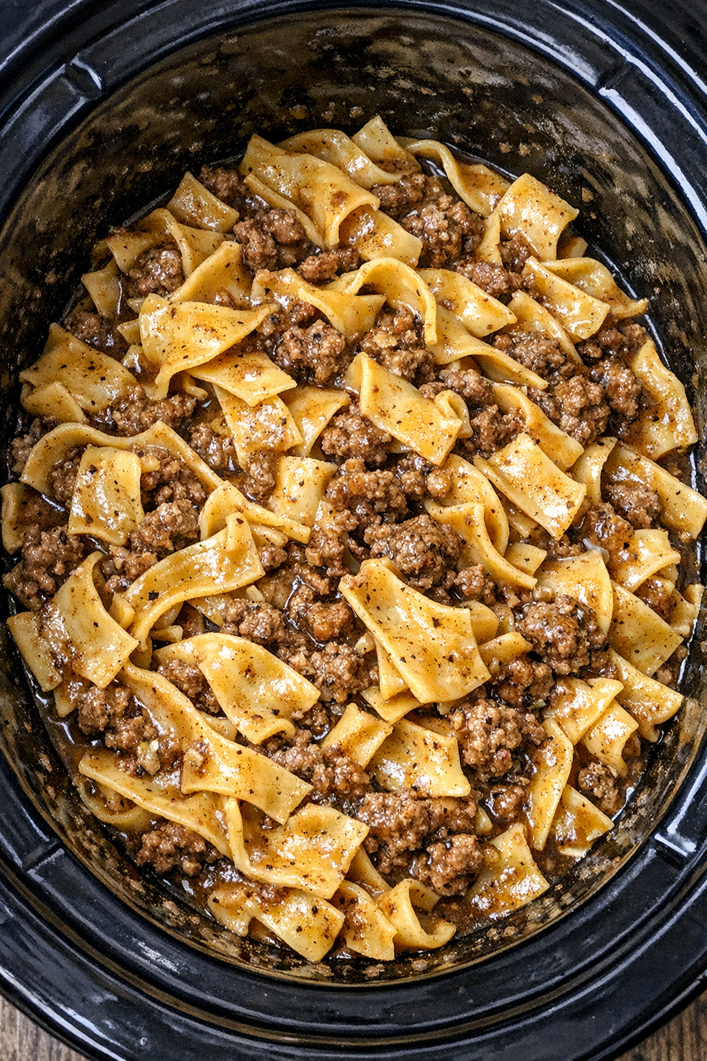 Slow cooker Amish ground beef noodles in a black slow cooker