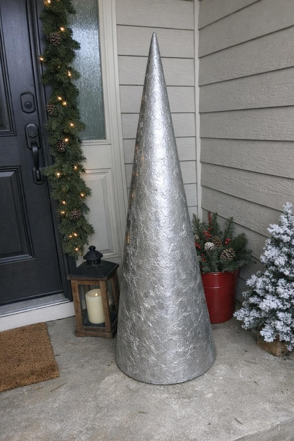 Tall concrete Christmas tree sculpture by a doorway