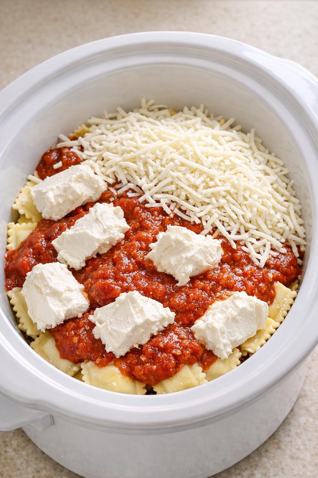 Roomkaas, saus en mozzarella toegevoegd aan ravioli