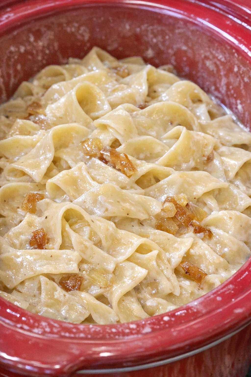 Creamy Amish onion noodles in a red slow cooker