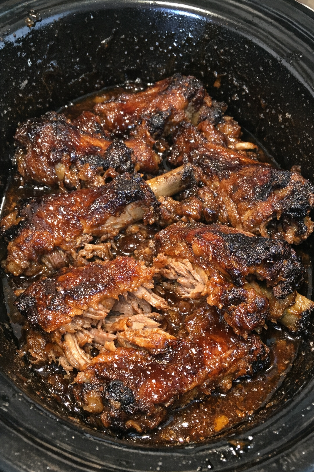 Slow cooker pork spareribs coated in thick amber sauce