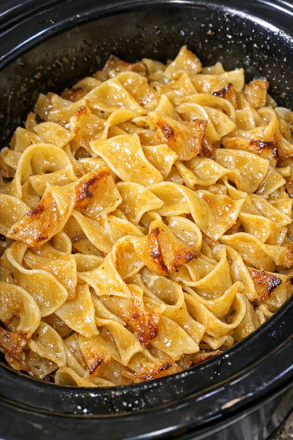 Slow cooker Amish honey butter noodles in a black slow cooker