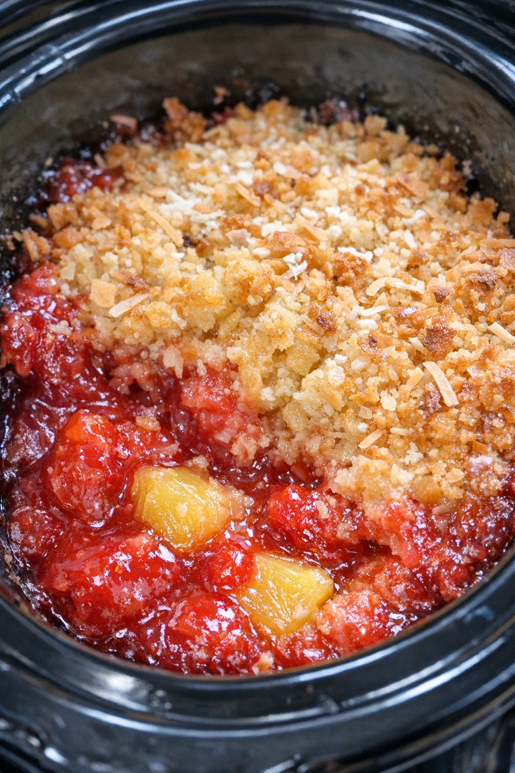 Slow cooker Miami Vice dump cake in a black slow cooker