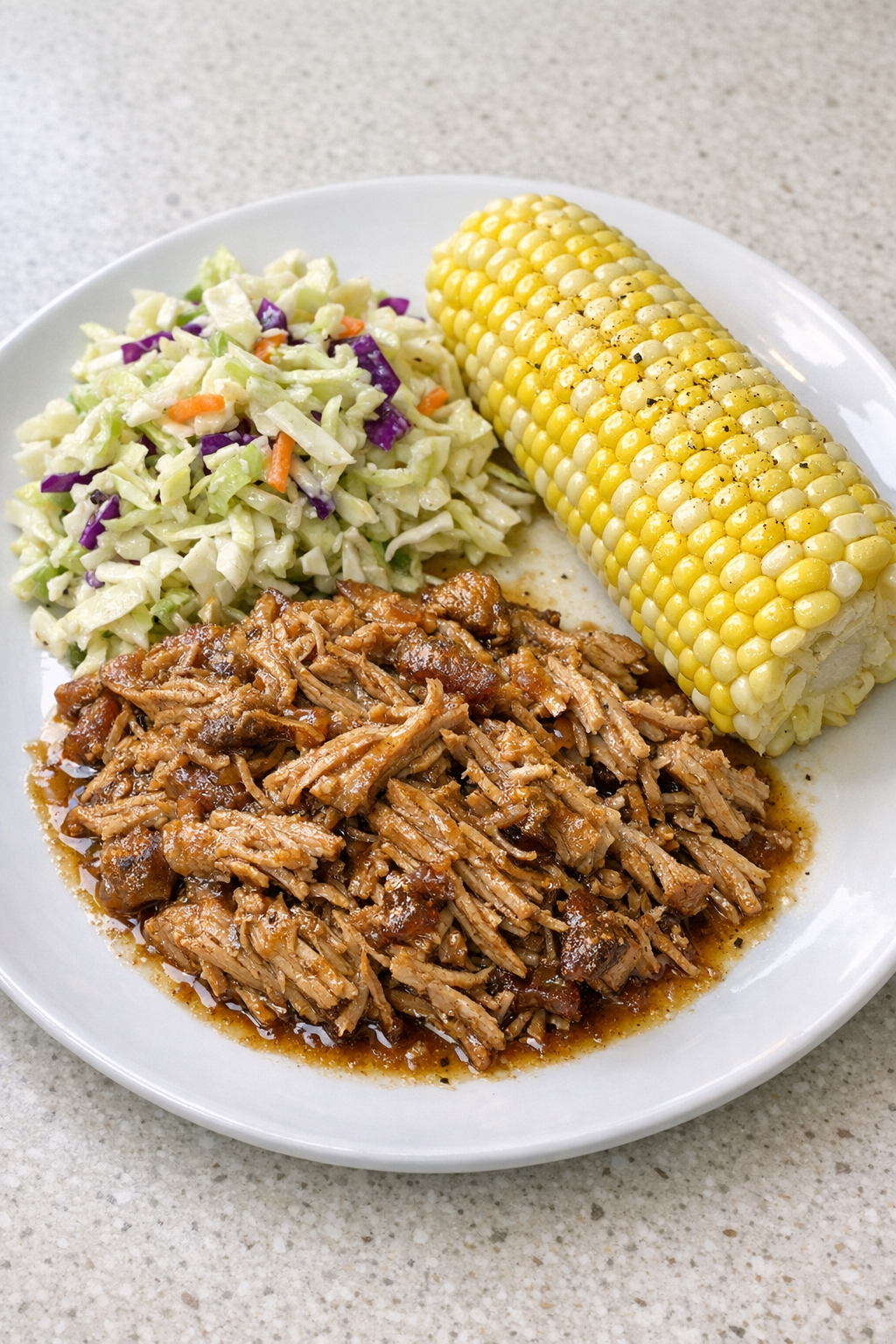 Finished slow cooker pork shoulder plated with summer sides