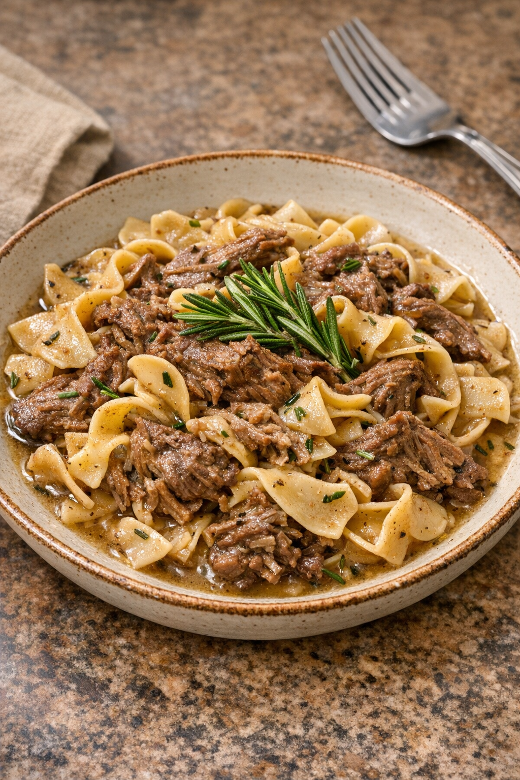 Finished rosemary beef pasta plated in a rustic bowl
