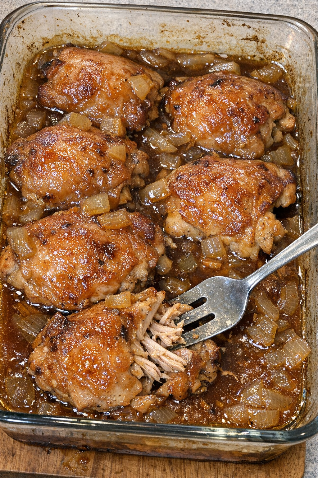 Chicken thighs in amber sauce in a baking dish