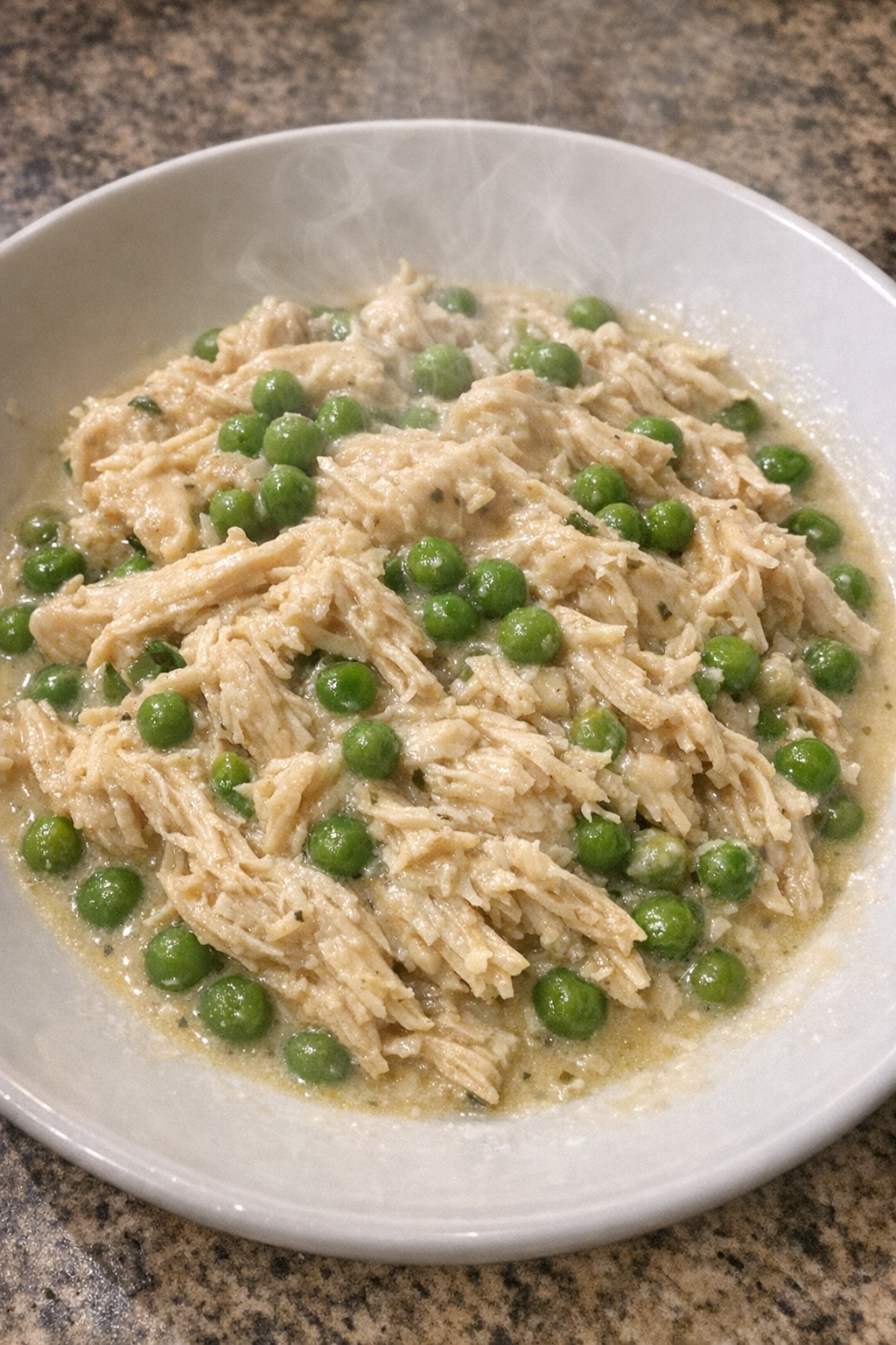 Slow cooker Amish chicken and peas on a white plate