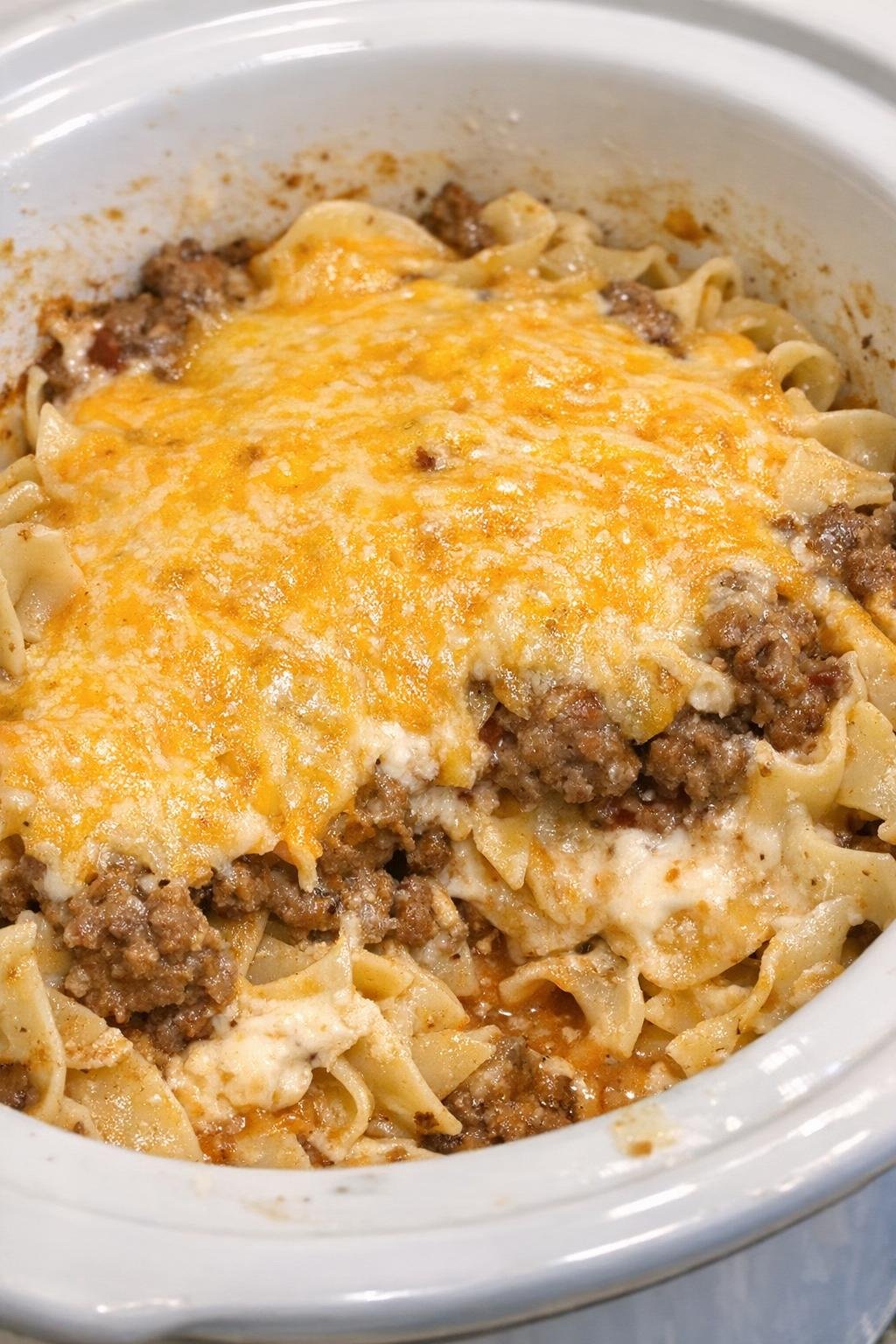 Slow cooker sour cream noodle bake in a white crock
