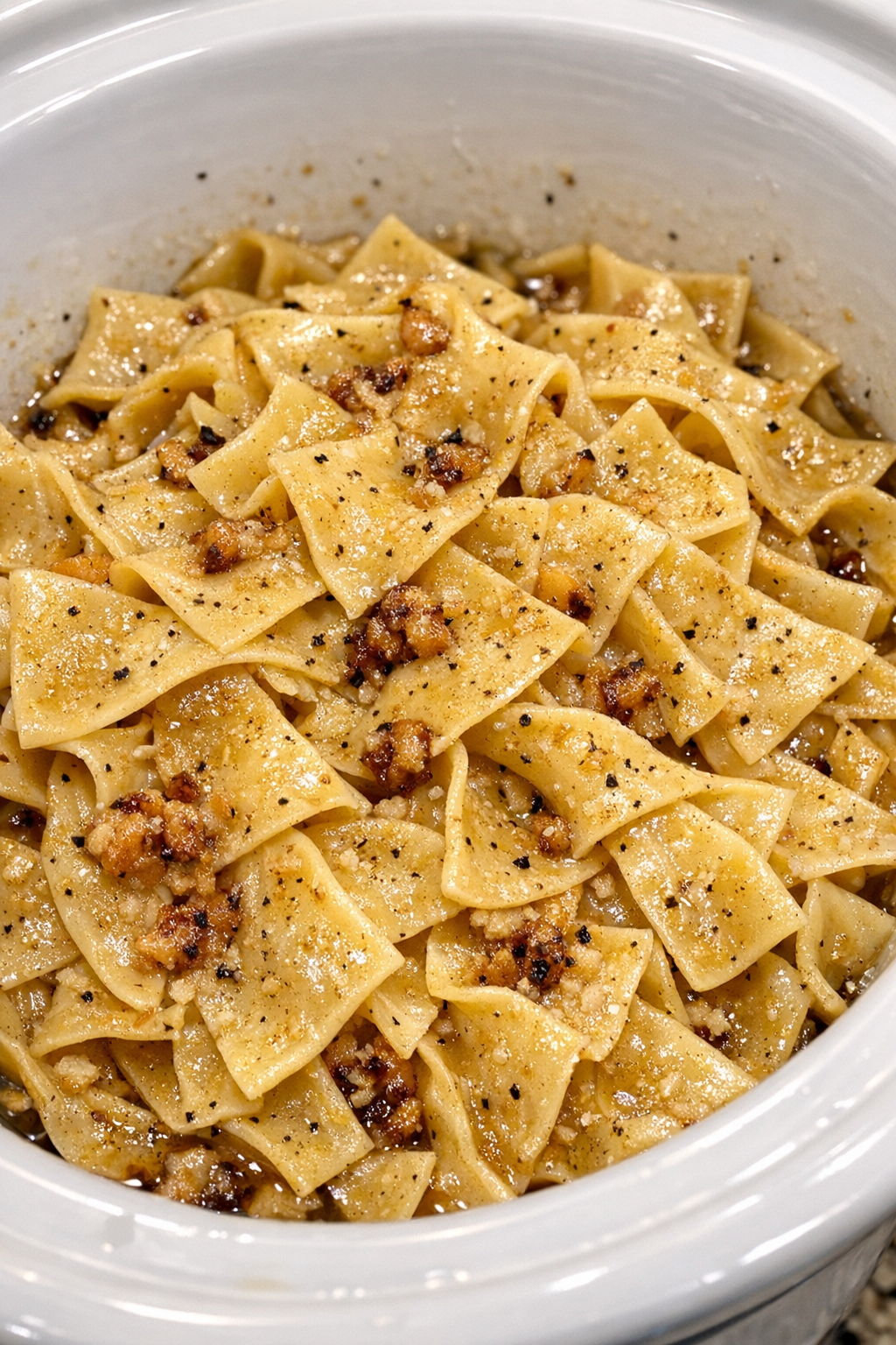Slow cooker Amish brown butter noodles in a white slow cooker
