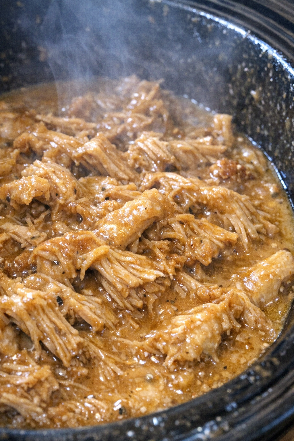 Shredded protein in creamy amber sauce in a slow cooker