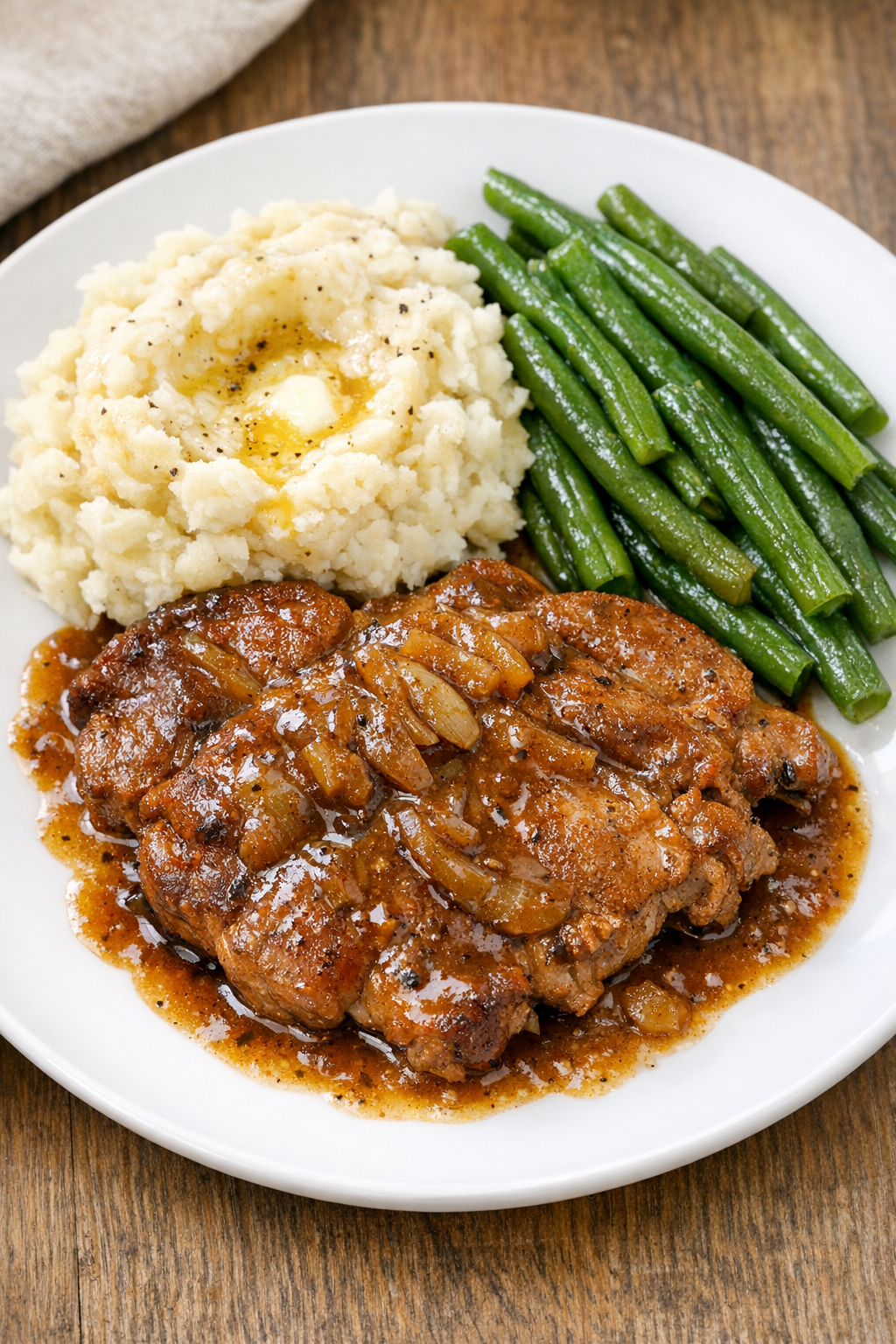Finished slow cooker pork blade steaks plated with sauce