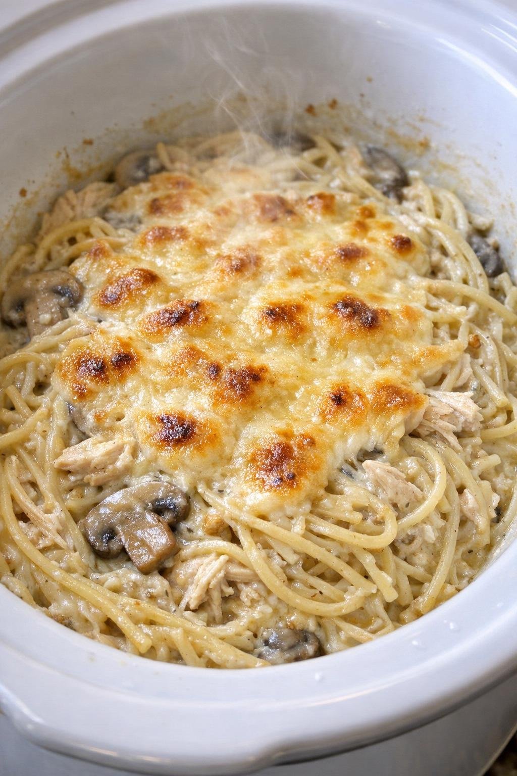 Slow cooker chicken tetrazzini in a white slow cooker crock