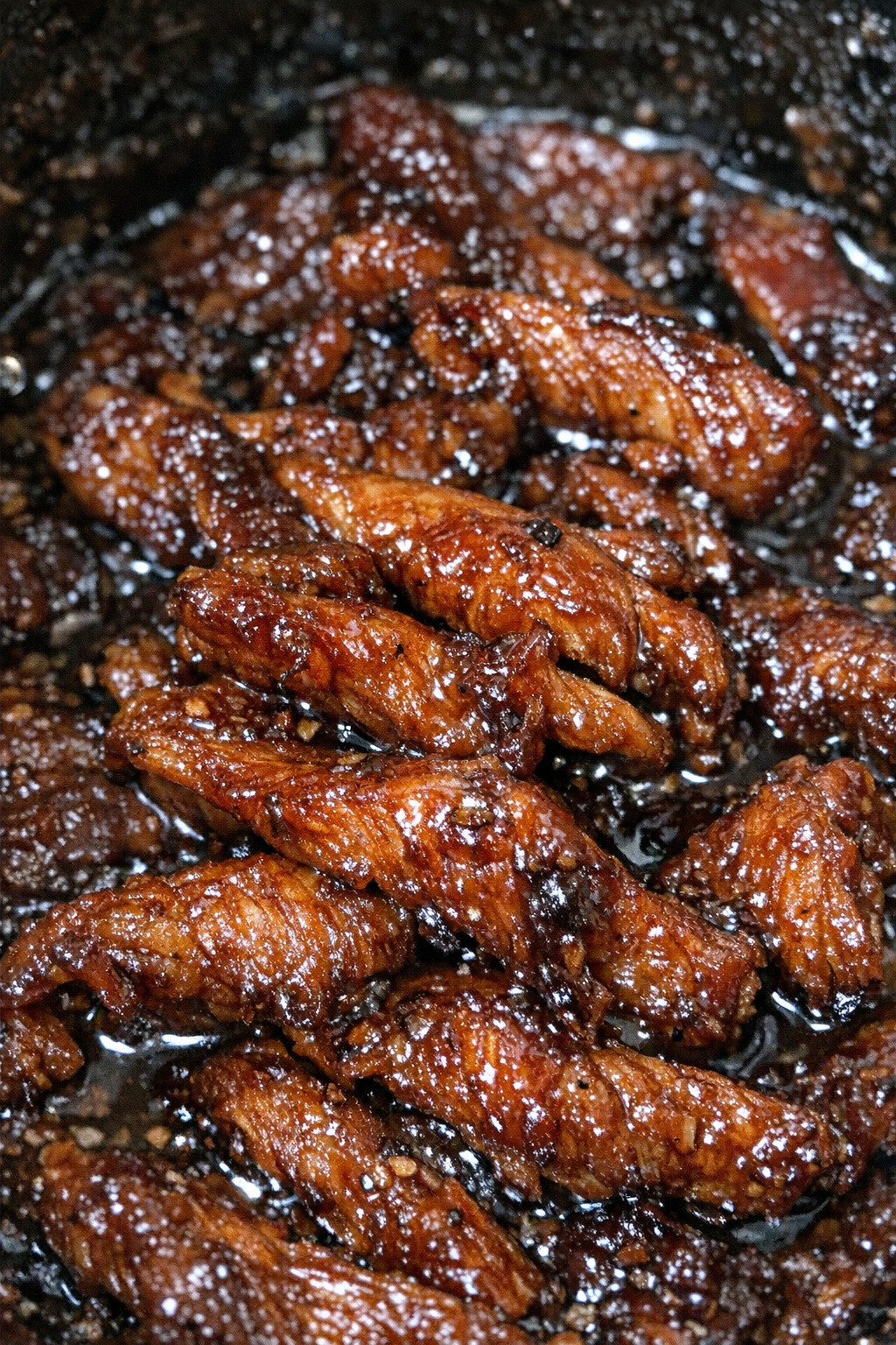 Sticky caramelized protein ribbons in mahogany sauce