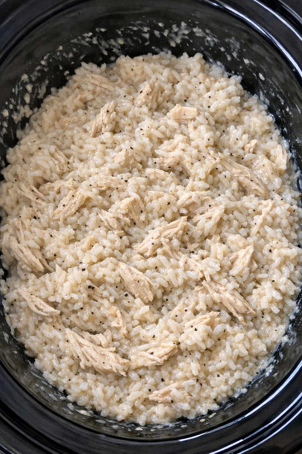 Slow cooker Amish chicken and rice in a black slow cooker