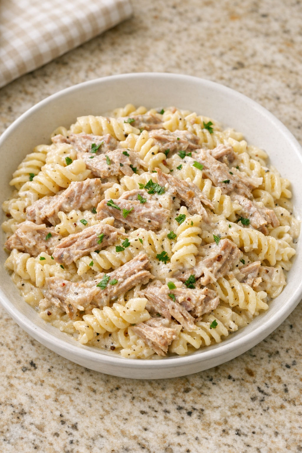 Creamy pork pasta plated in a shallow bowl