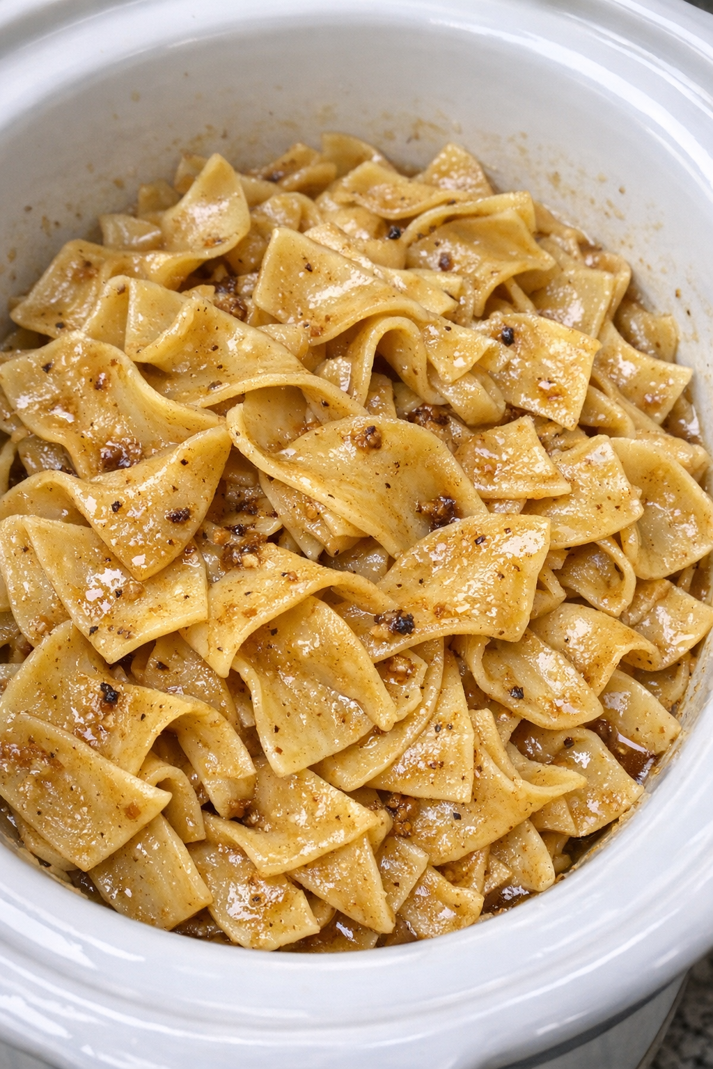 Slow cooker Amish brown butter noodles in a white slow cooker
