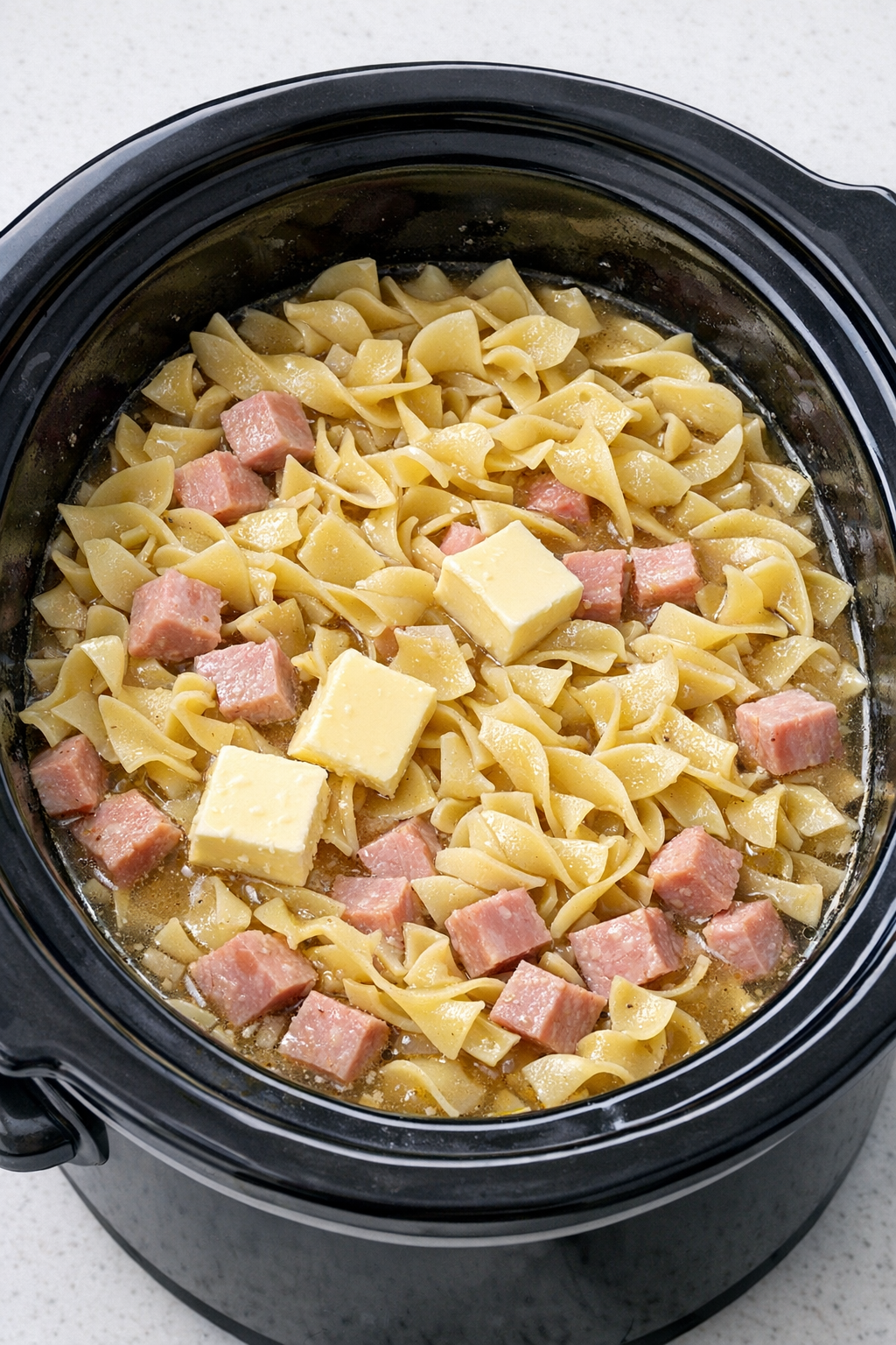 Egg noodles and butter added to the slow cooker