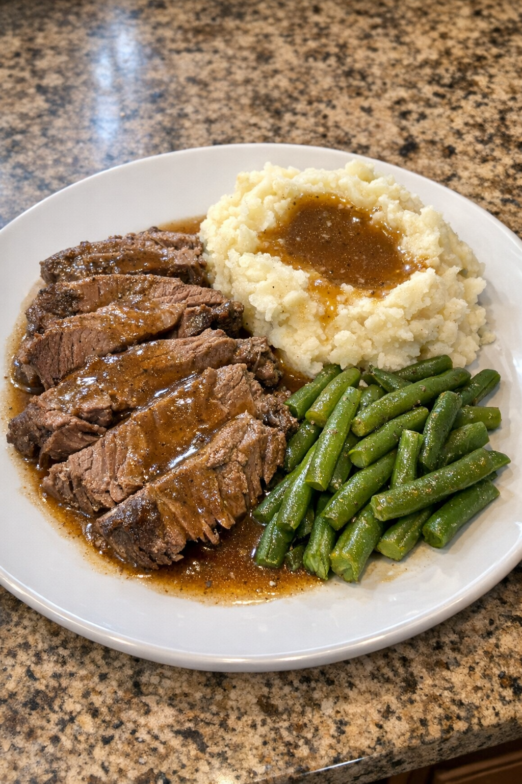 Finished Amish-style beef roast plated with potatoes and vegetables