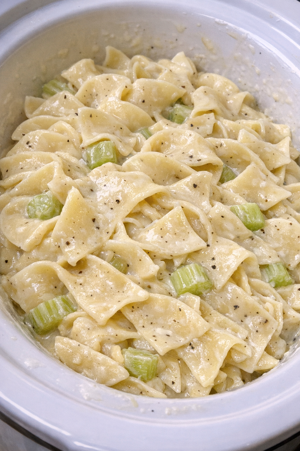 Creamy celery noodles in a white slow cooker