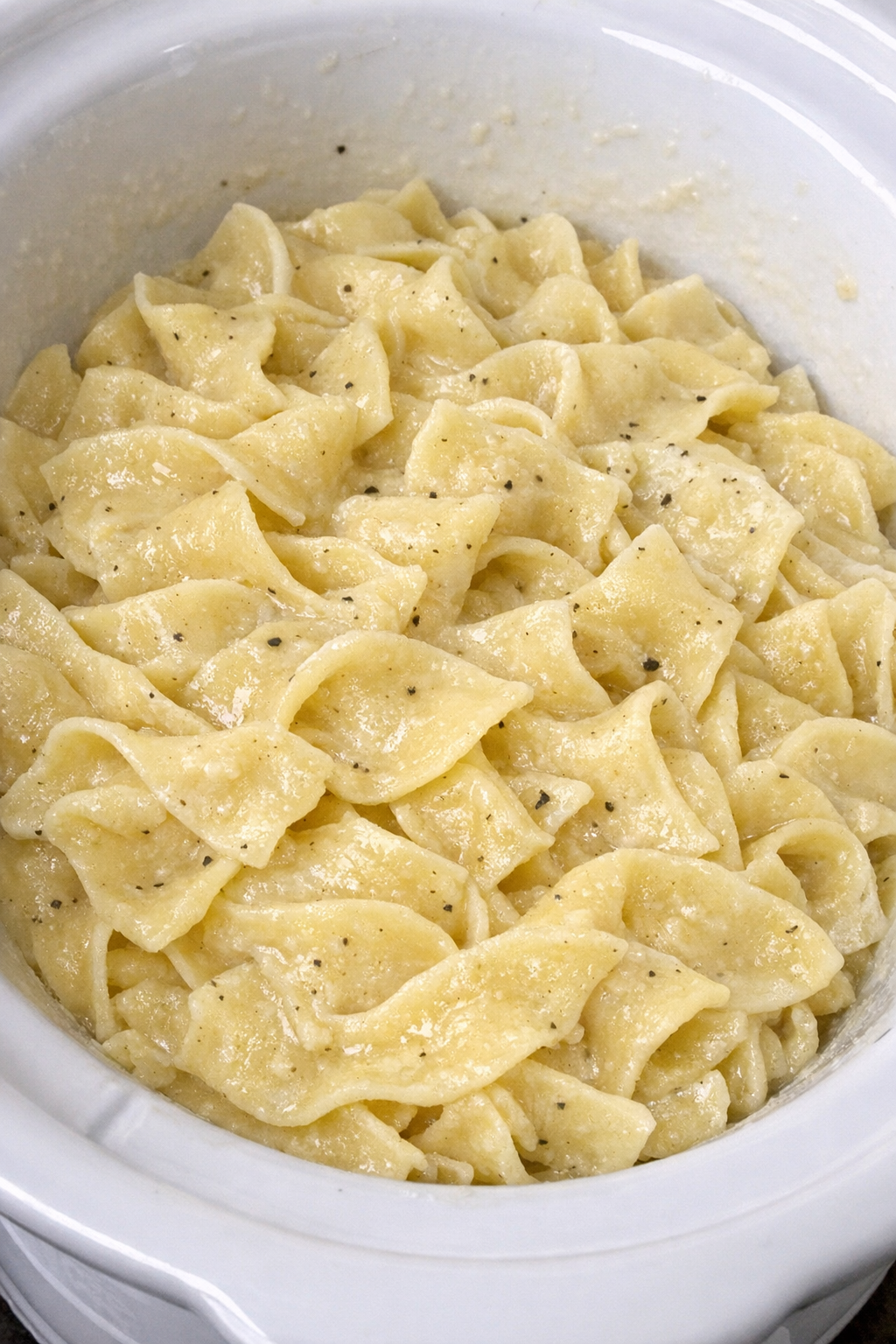 Slow cooker Amish egg noodles in a white slow cooker