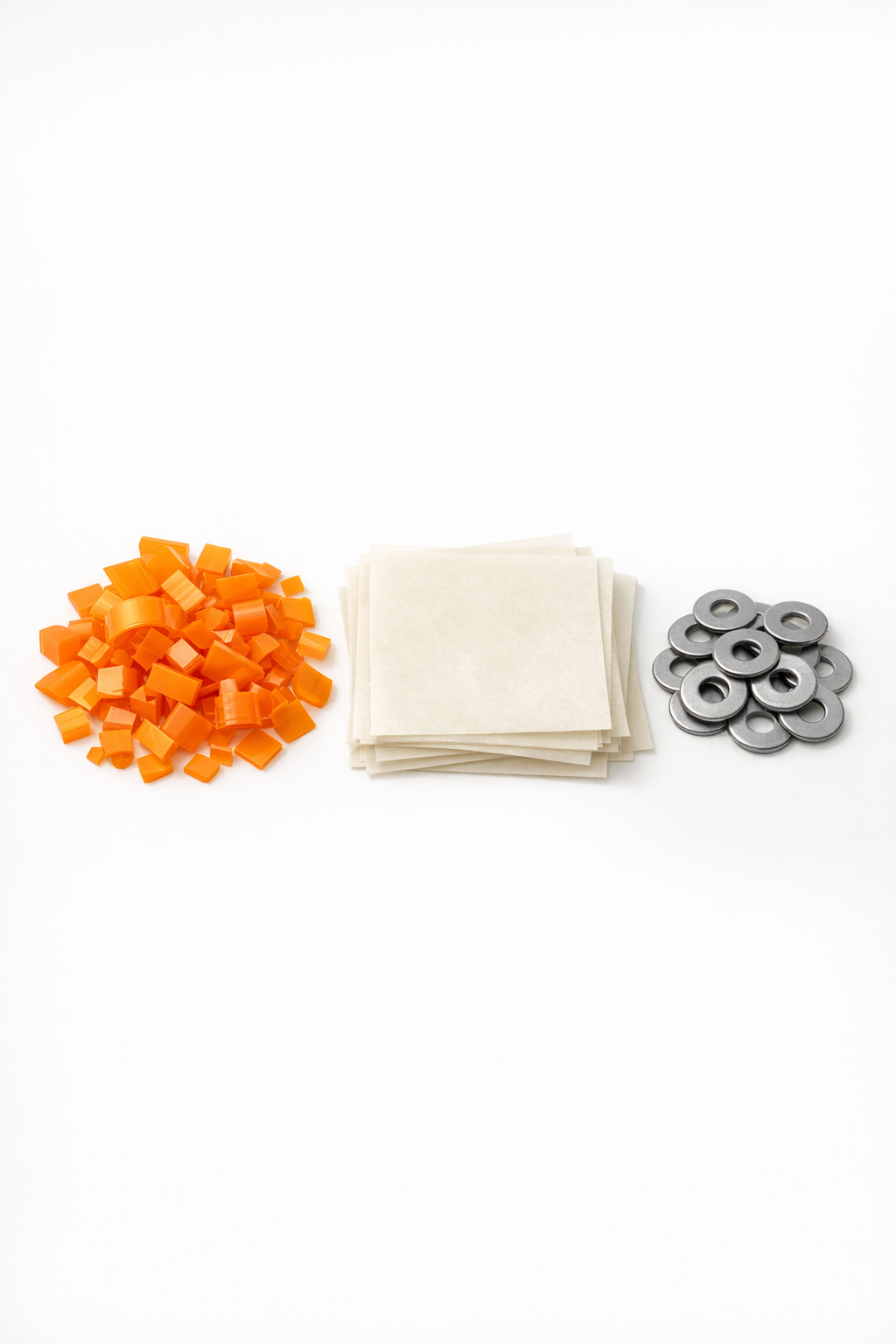 Chopped prescription bottle plastic, parchment paper, and metal washers laid out for the project