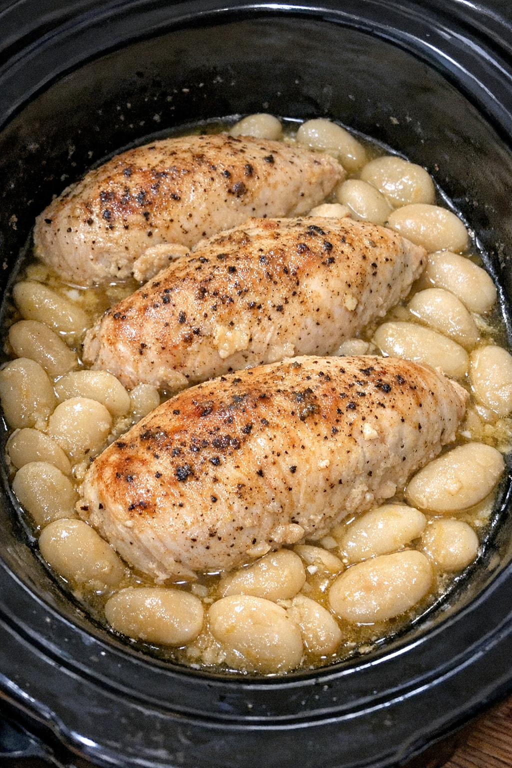 Slow cooker Amish chicken and butter beans in a black slow cooker