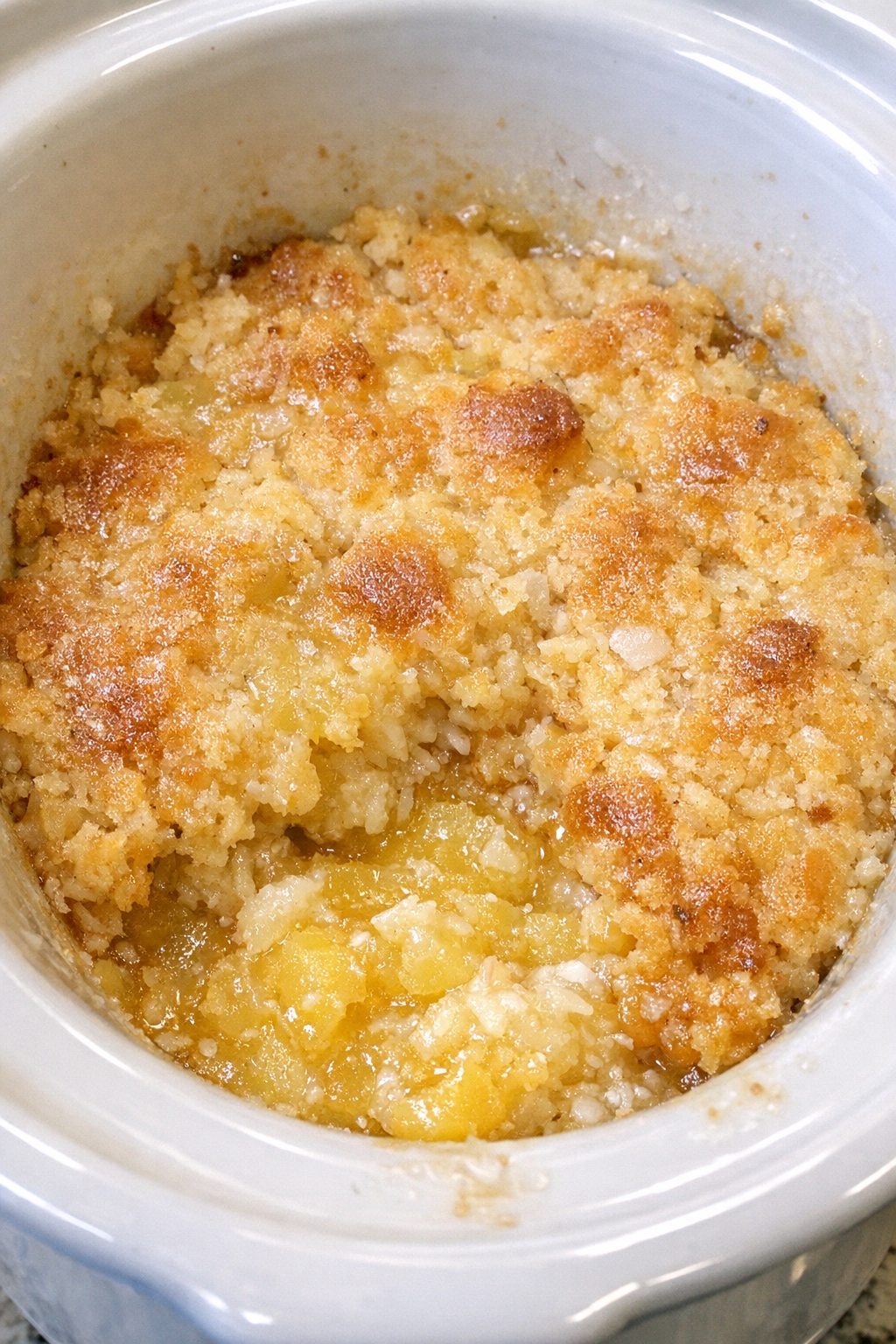 Slow cooker pina colada dump cake in a white slow cooker