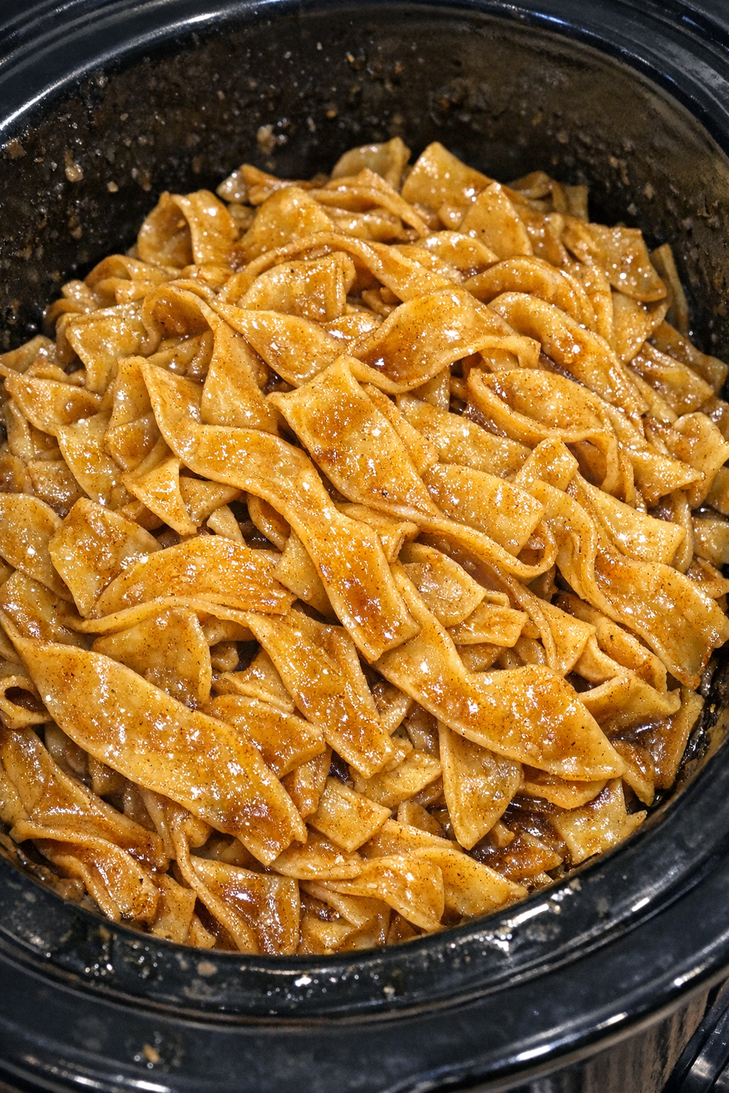 Slow cooker Amish brown sugar noodles in a black slow cooker