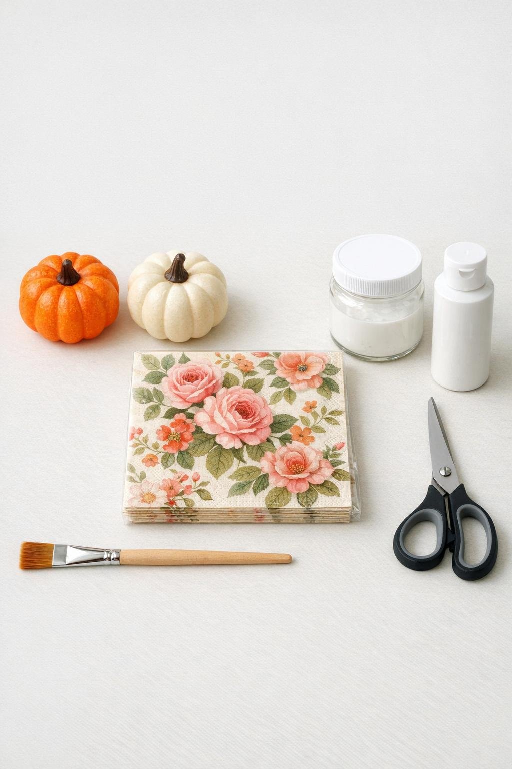 Materials for decoupage foam pumpkins laid out on a table