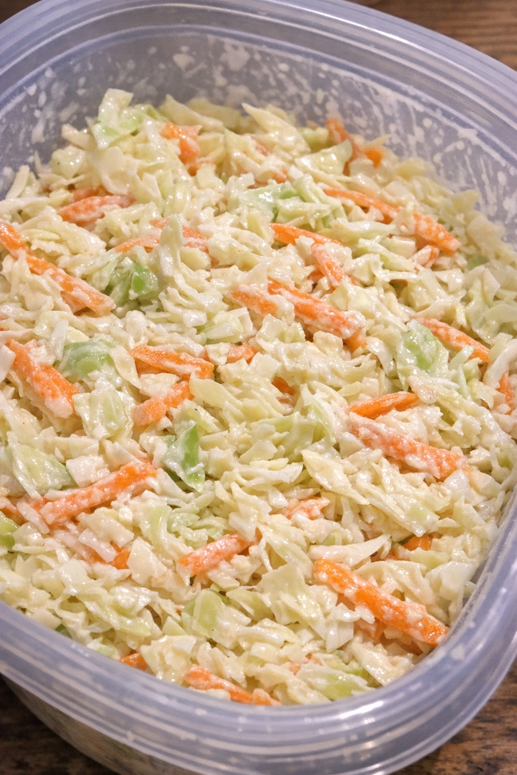 Classic coleslaw in a large plastic container