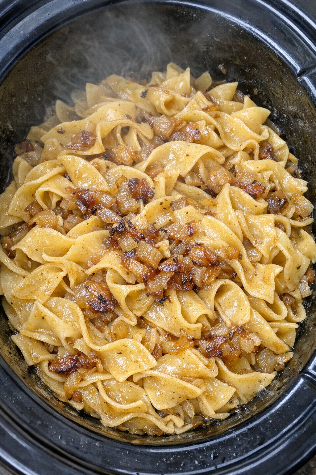 Slow cooker Amish browned onion noodles in a black slow cooker