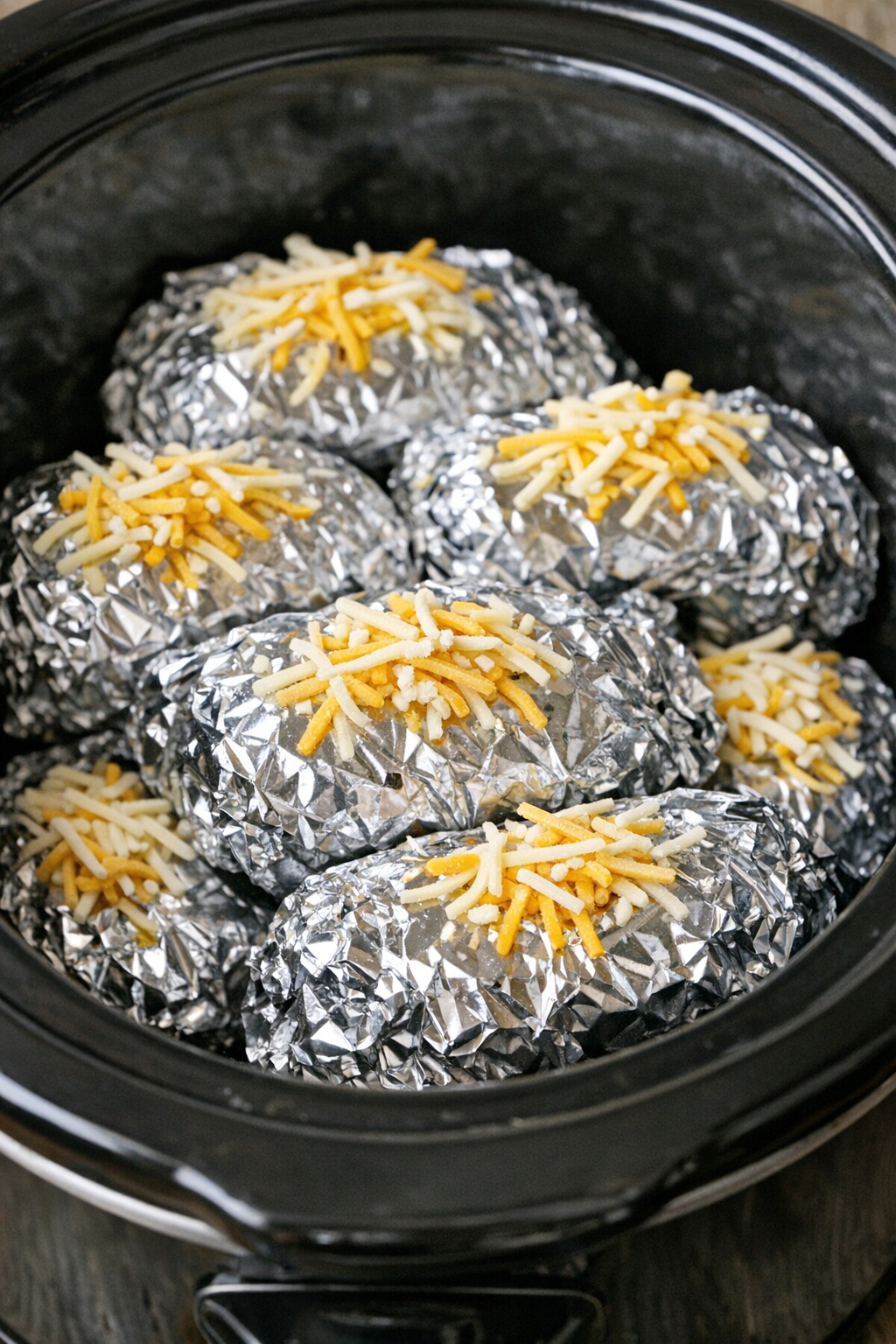 Slow cooker beef enchilada foil packets in a black slow cooker