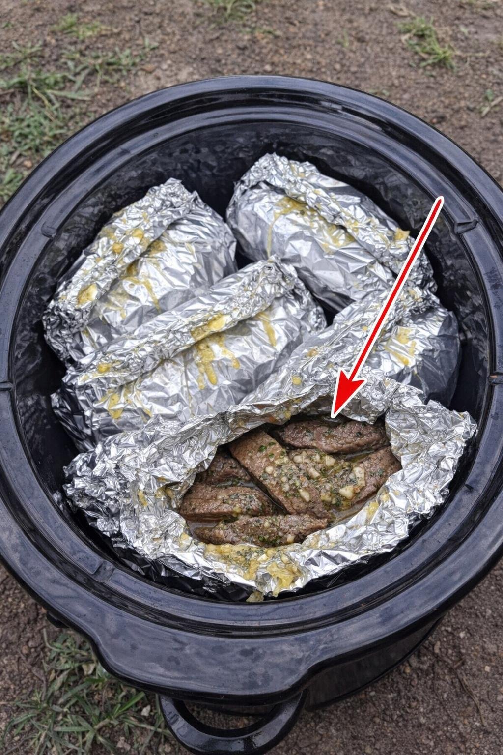 Slow cooker foil steak packets in a black slow cooker