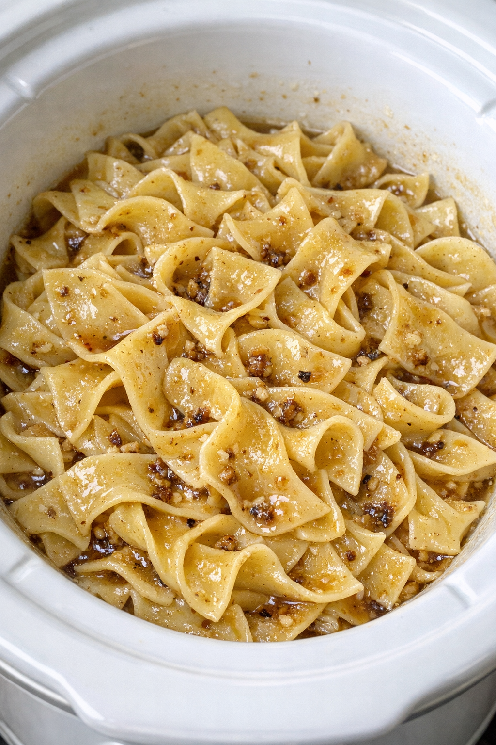 Slow cooker Amish brown butter noodles in a white slow cooker