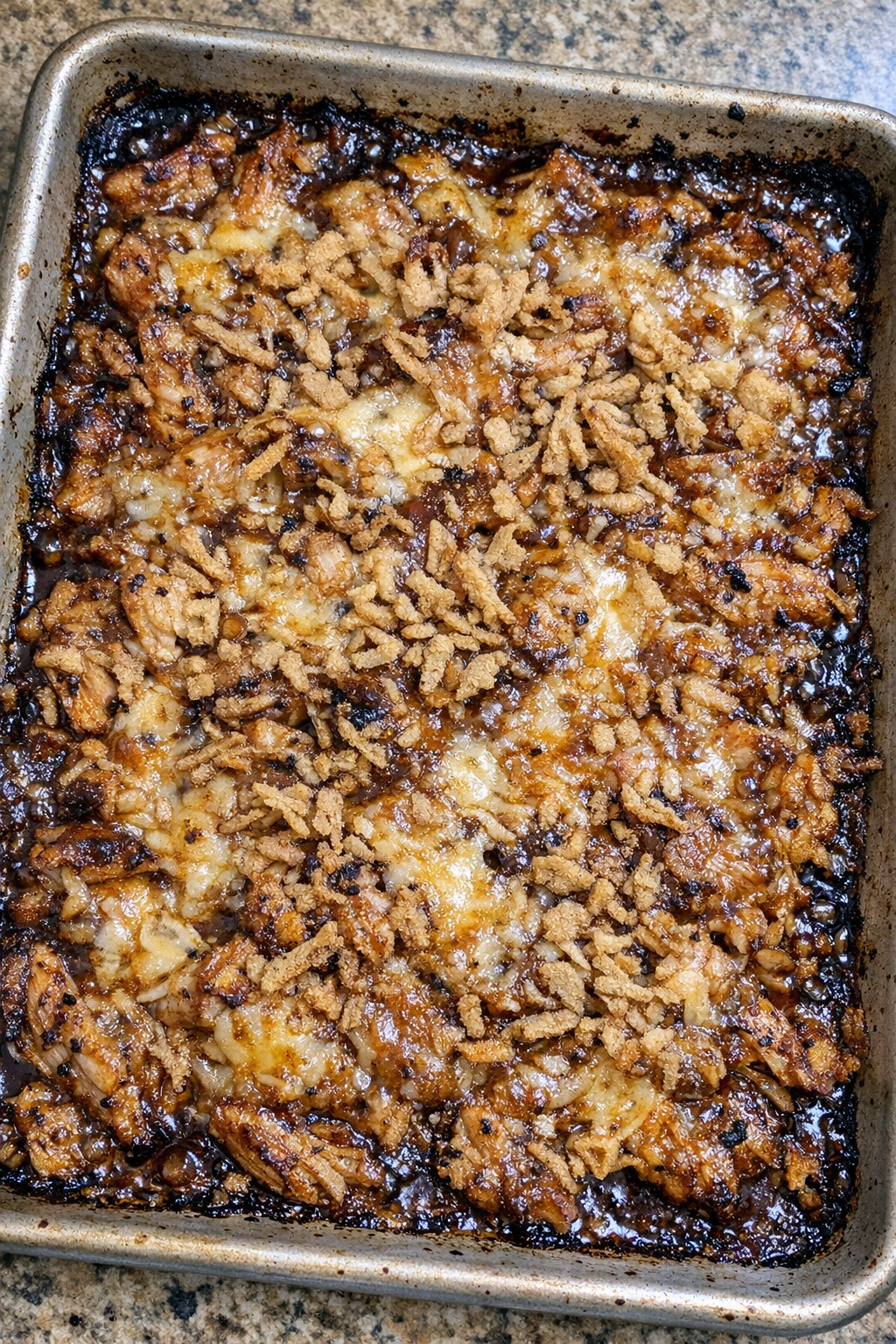 Bubbling caramelized chicken bake in a metal baking sheet