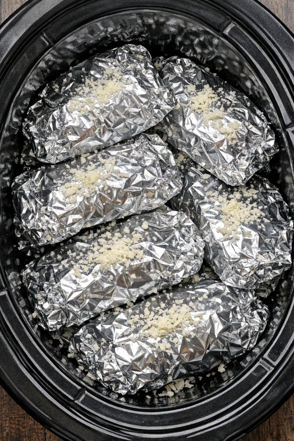 Slow cooker cheesy pepperoni tortellini foil packets in a black slow cooker