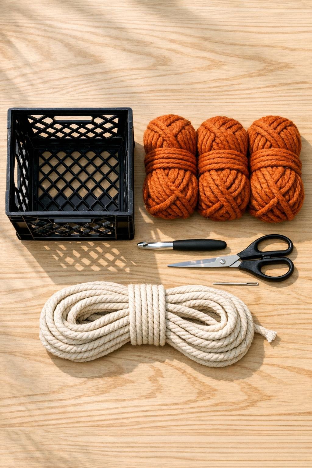 Materials for a crochet-covered milk crate basket laid out neatly