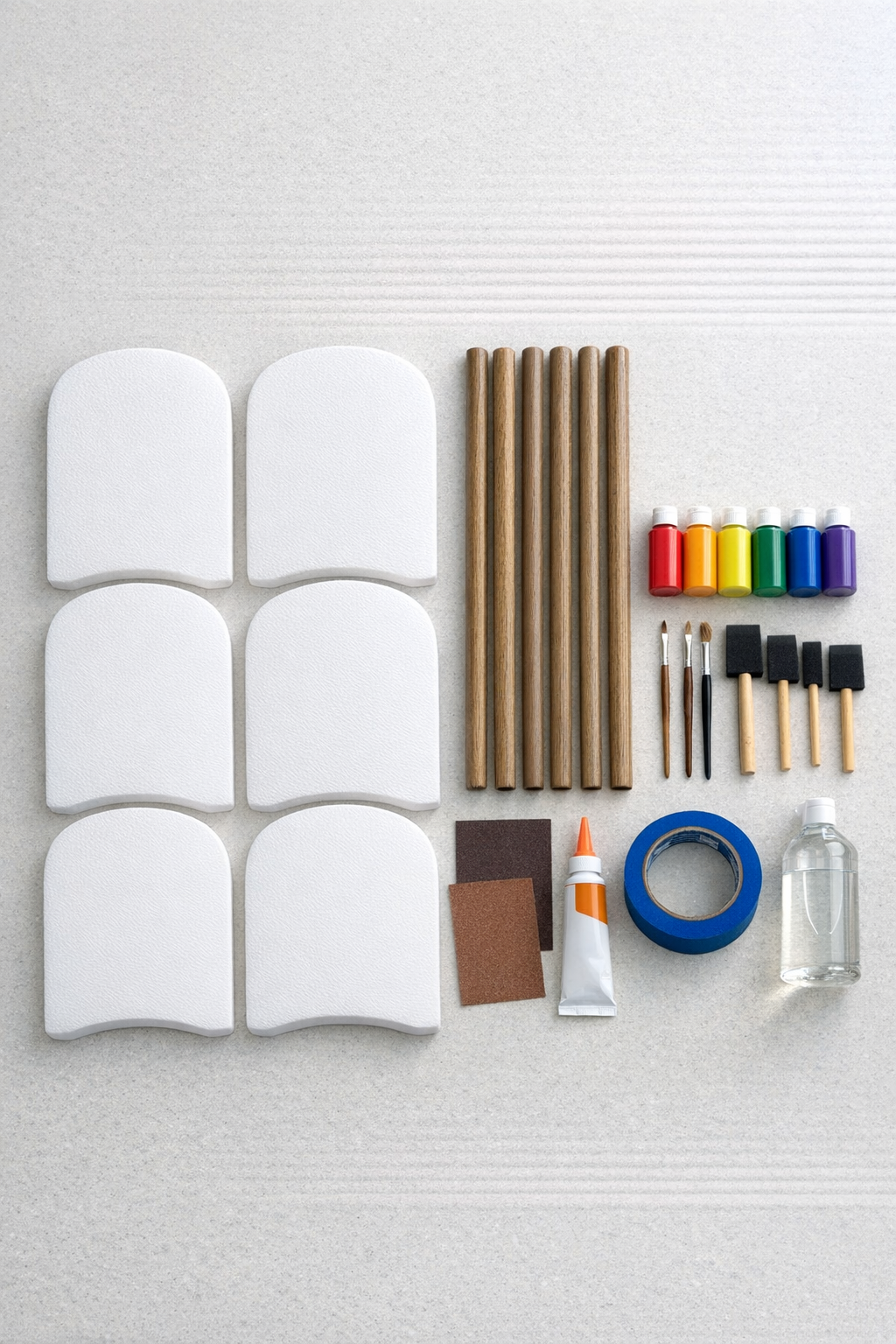 Foam kickboards, brown broom handles, paint, brushes, sandpaper, adhesive, and sealing supplies laid out for the project