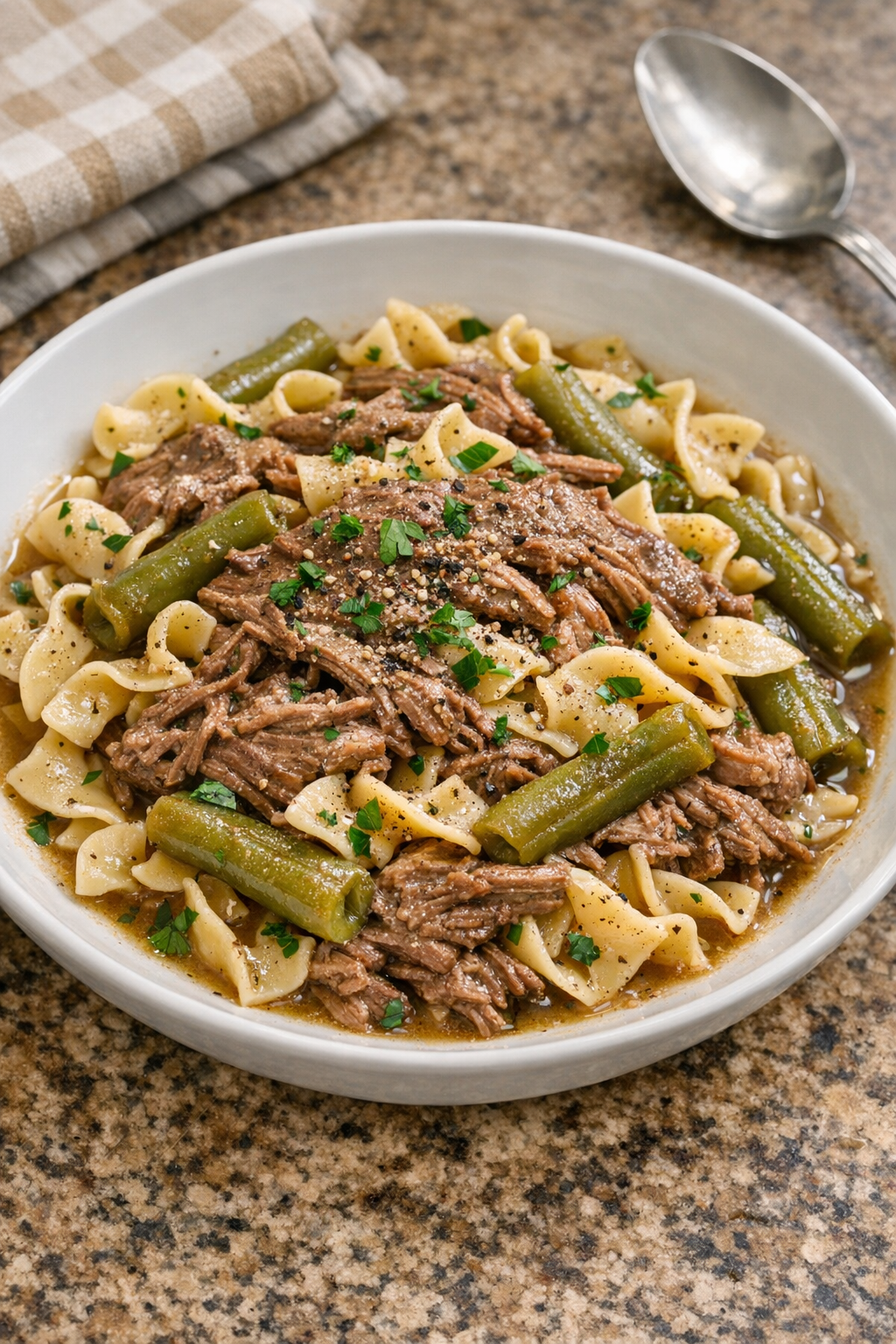 Finished Amish-style beef, green beans, and pasta plated in a bowl