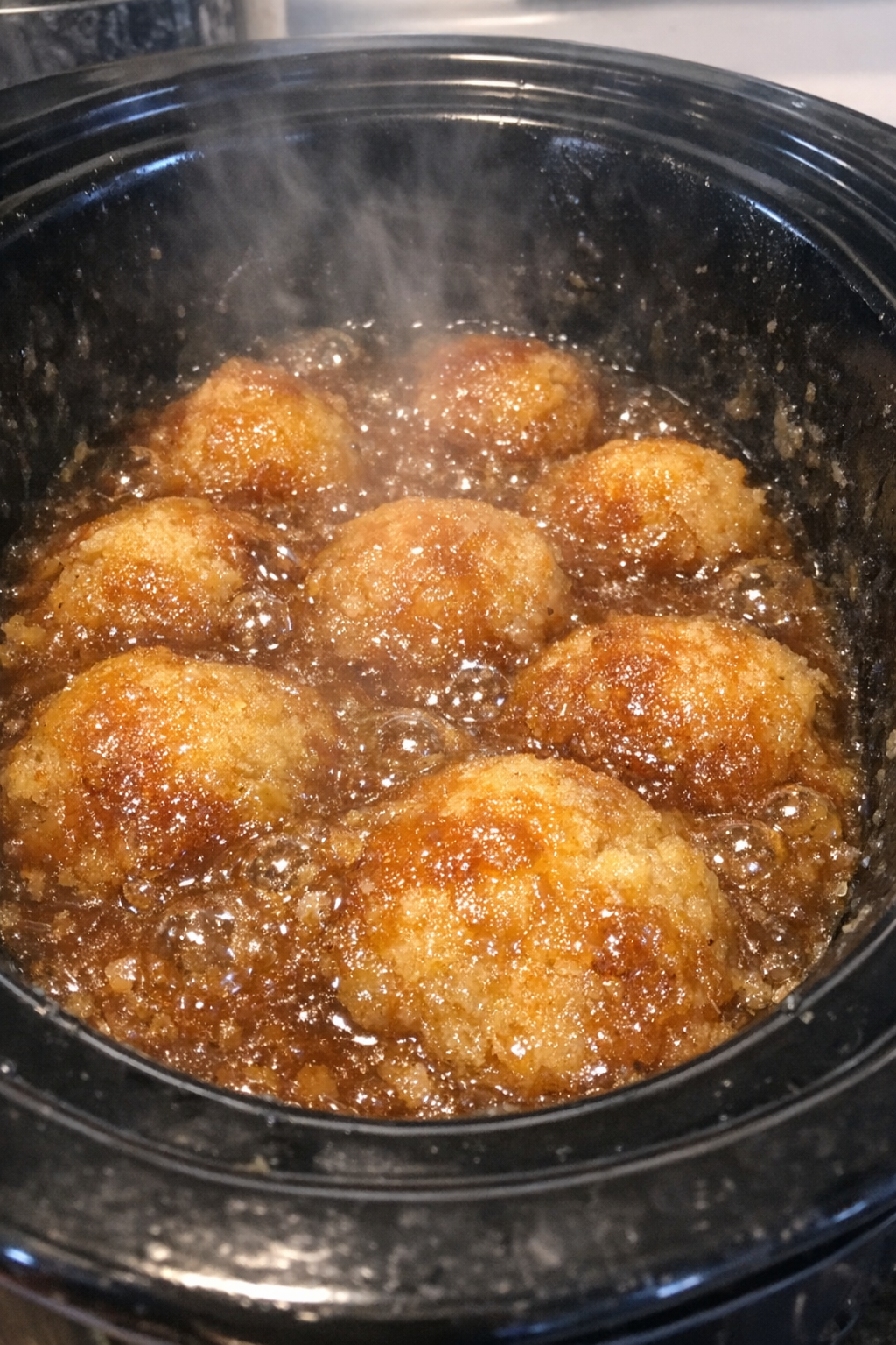 Slow cooker dessert with bubbling amber sauce and golden baked pieces